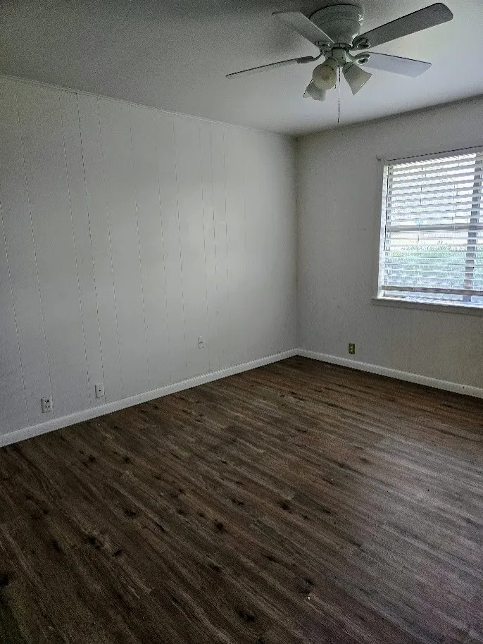Spare room featuring a ceiling fan, dark wood-type flooring, and a textured ceiling