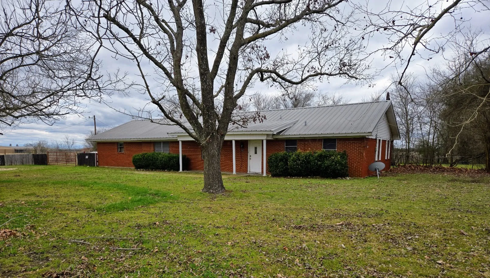 Ranch-style home with brick siding and a metal roof