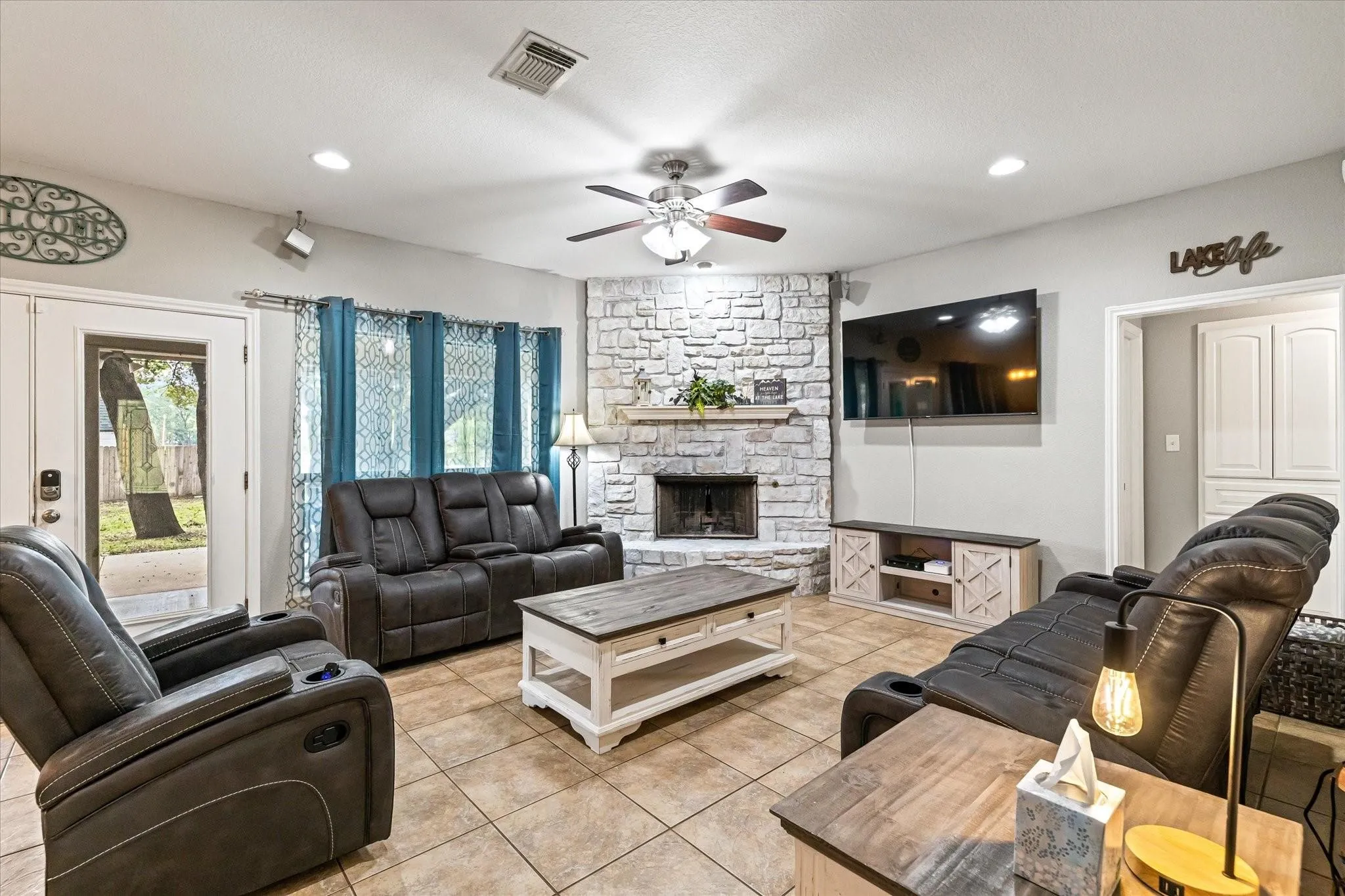 Living room with visible vents, ceiling fan, a fireplace, recessed lighting, and light tile patterned flooring