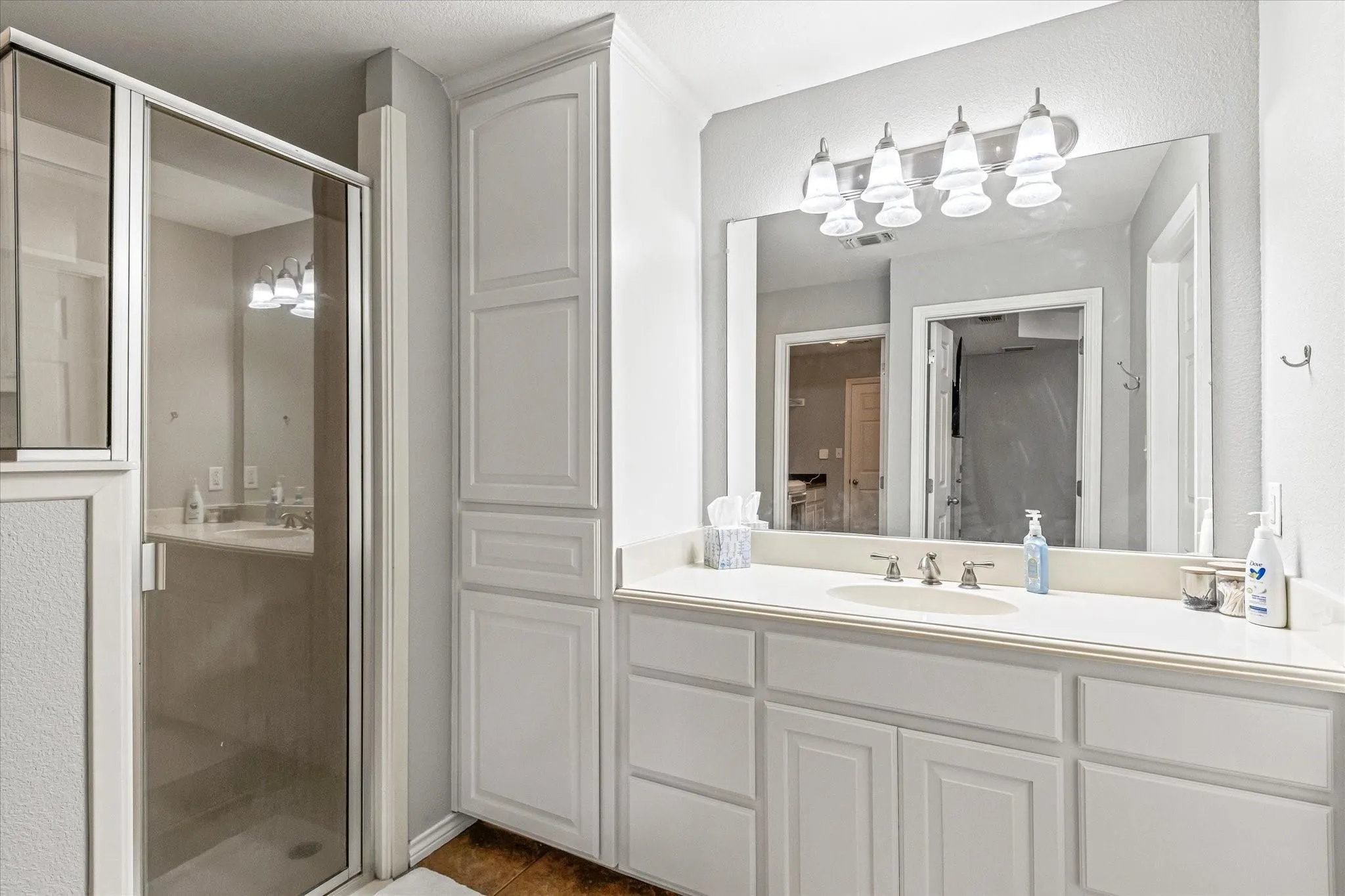 Bathroom featuring visible vents, tile patterned floors, a stall shower, and vanity