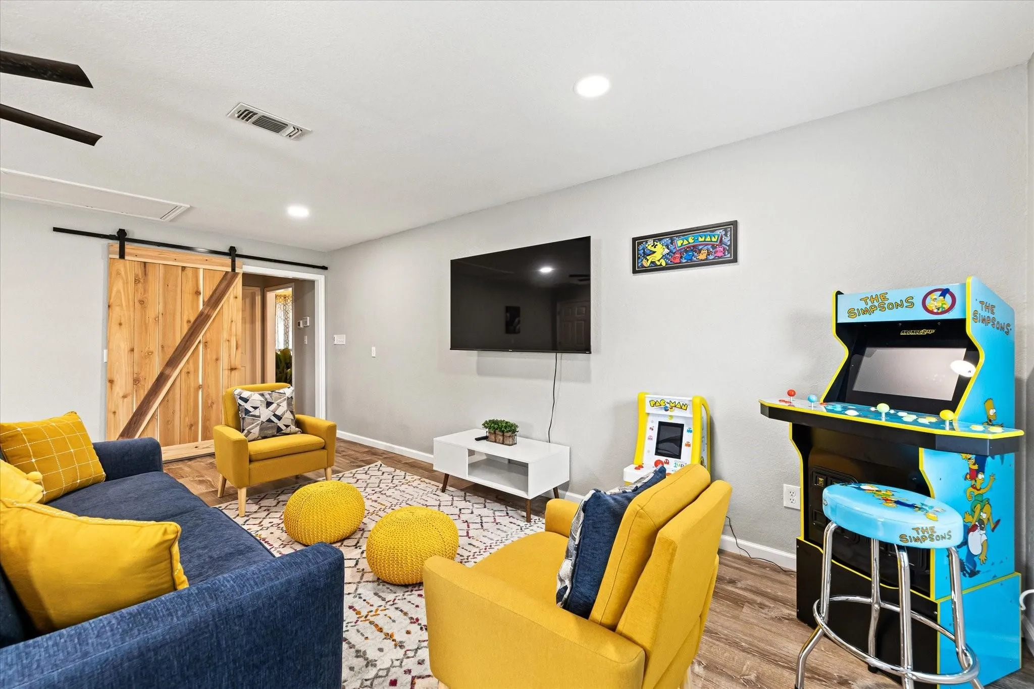 Living room featuring visible vents, recessed lighting, a barn door, wood finished floors, and baseboards