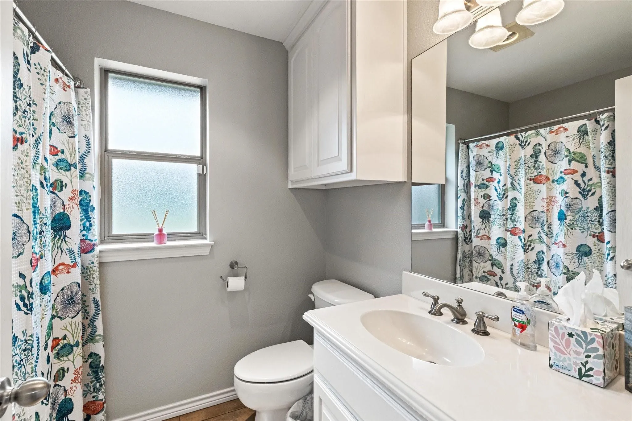 Full bath with toilet, a chandelier, vanity, and baseboards