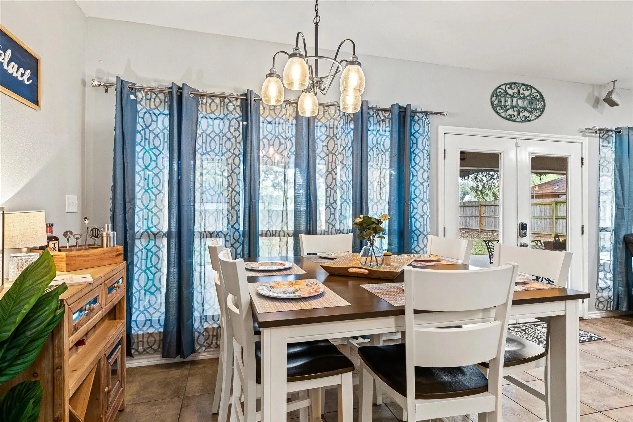 Dining area featuring tile patterned floors, french doors, and an inviting chandelier