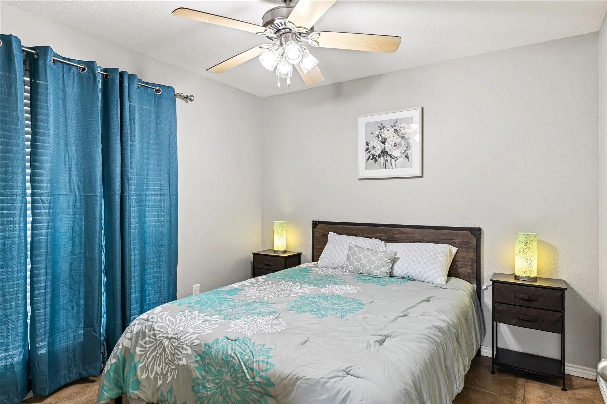 Bedroom with tile patterned floors, baseboards, and a ceiling fan
