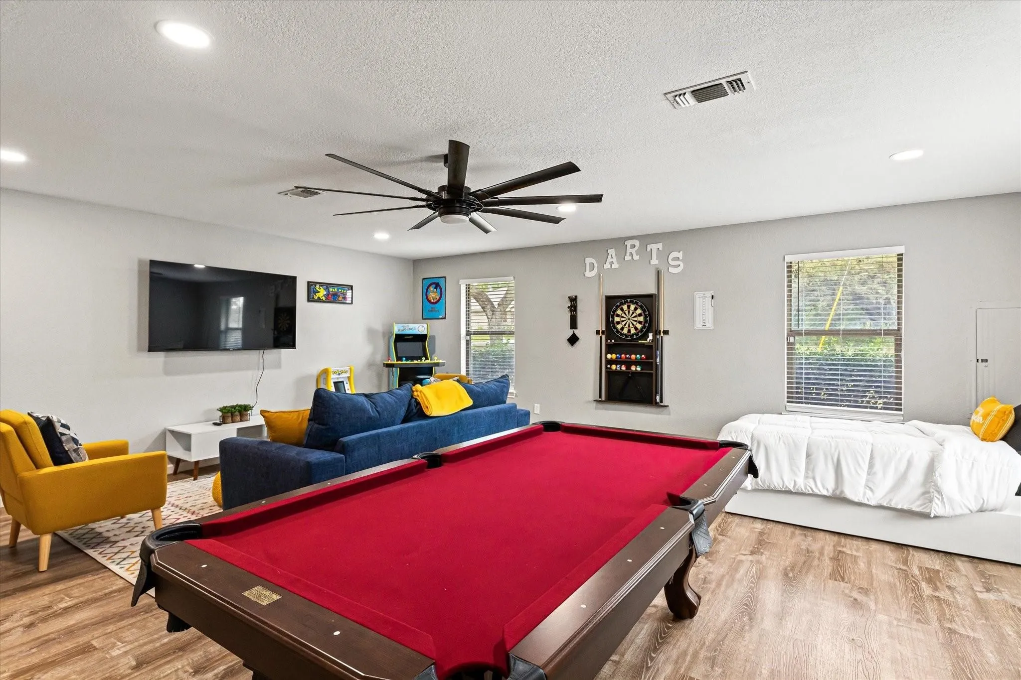Recreation room featuring a healthy amount of sunlight, visible vents, and wood finished floors
