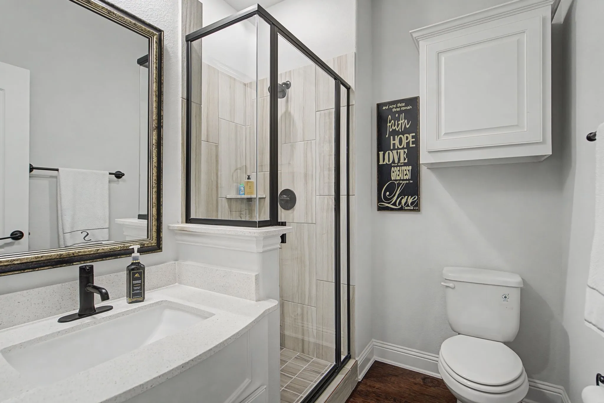 Bathroom with a stall shower, vanity, and dark wood-type flooring