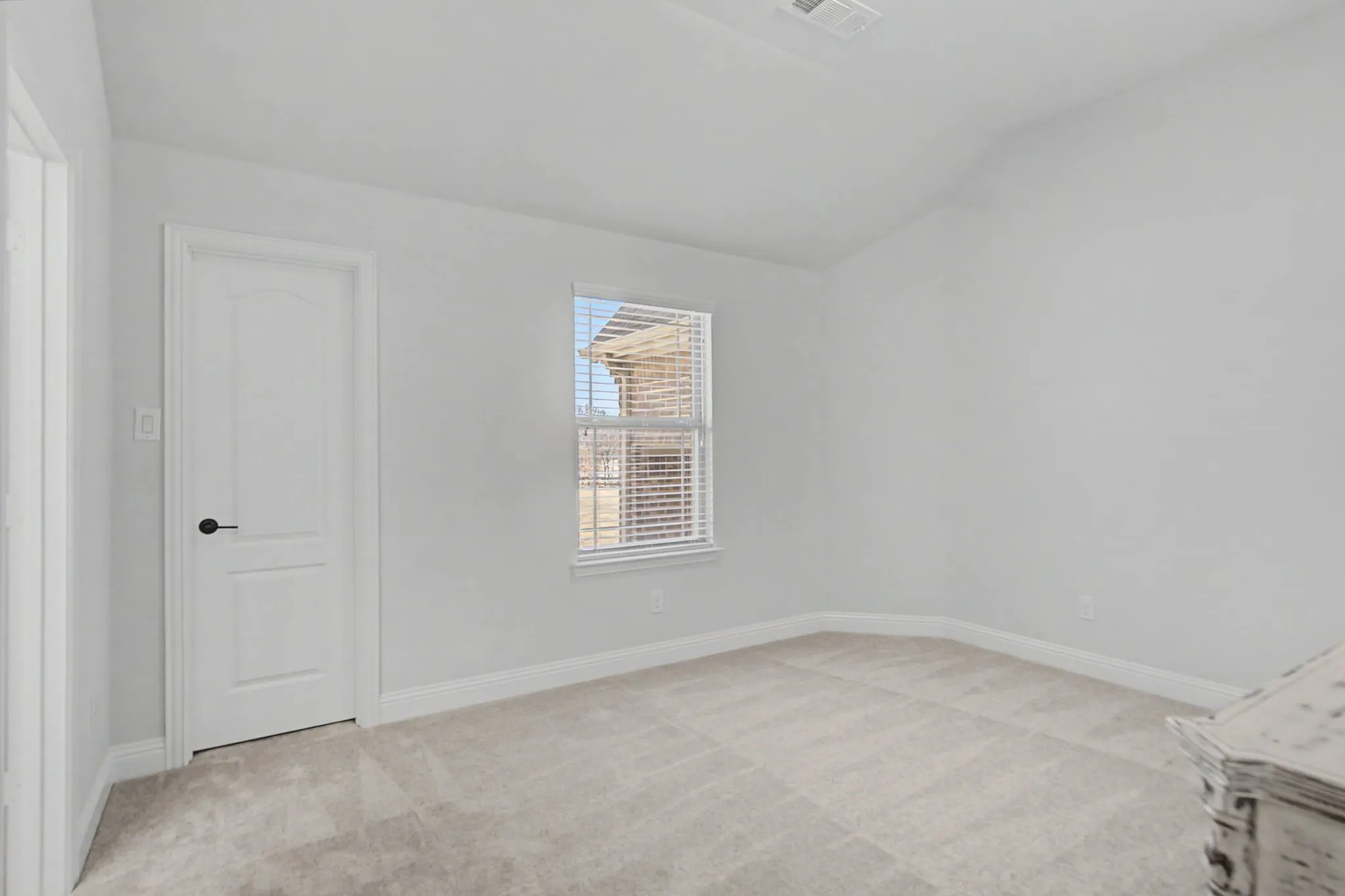 Bedroom with light carpet and vaulted ceiling