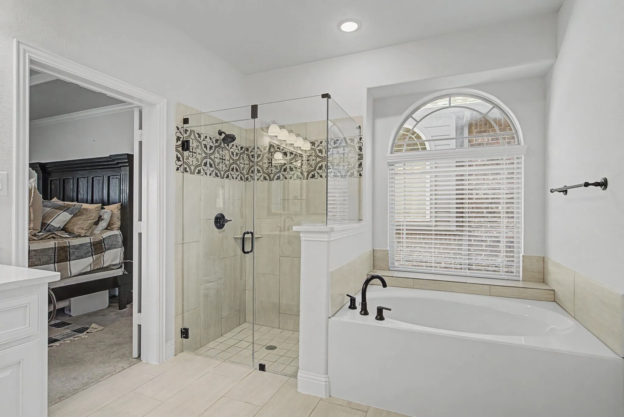 Ensuite bathroom with a stall shower, a bath, and light tile patterned floors