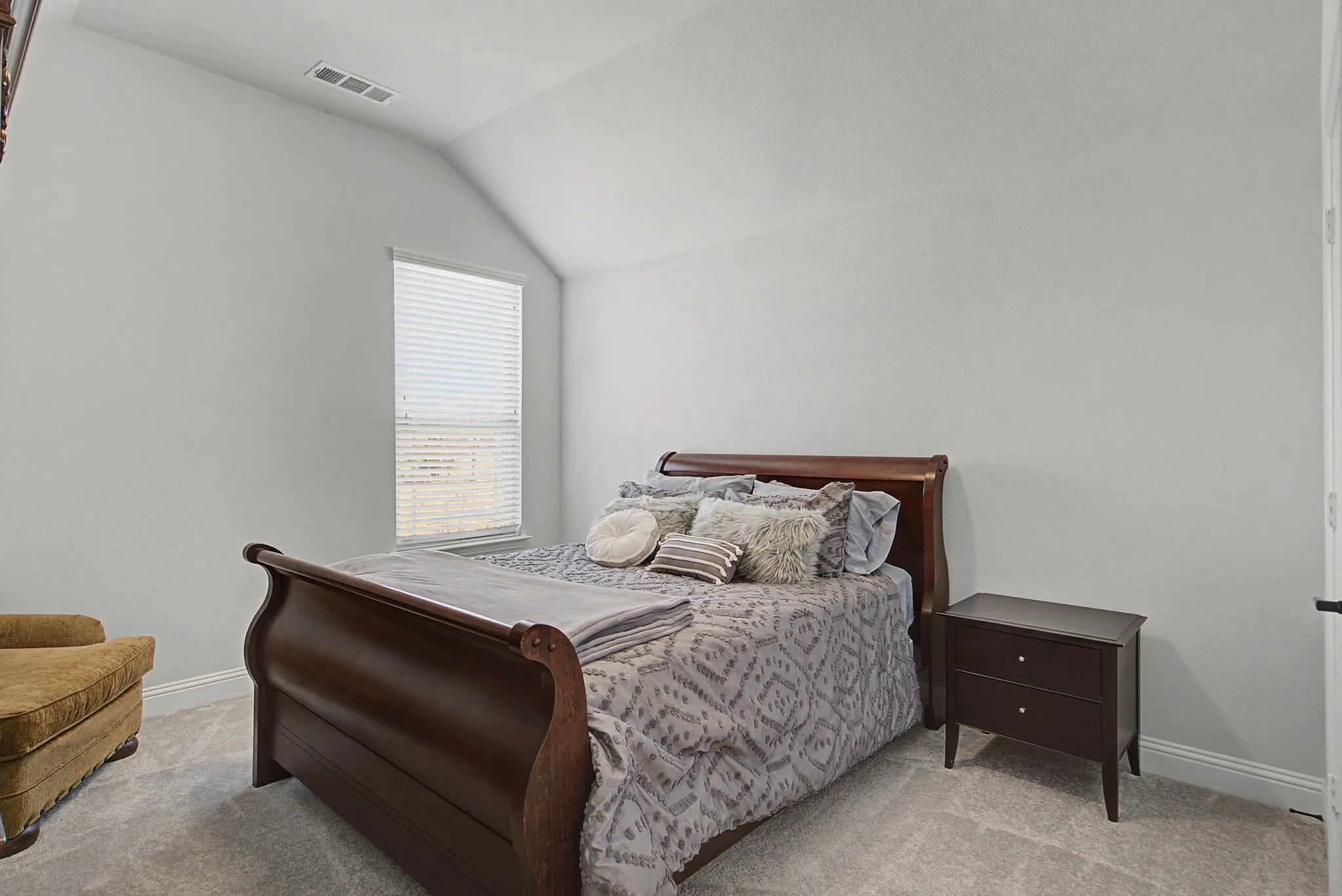 Carpeted bedroom with baseboards and vaulted ceiling