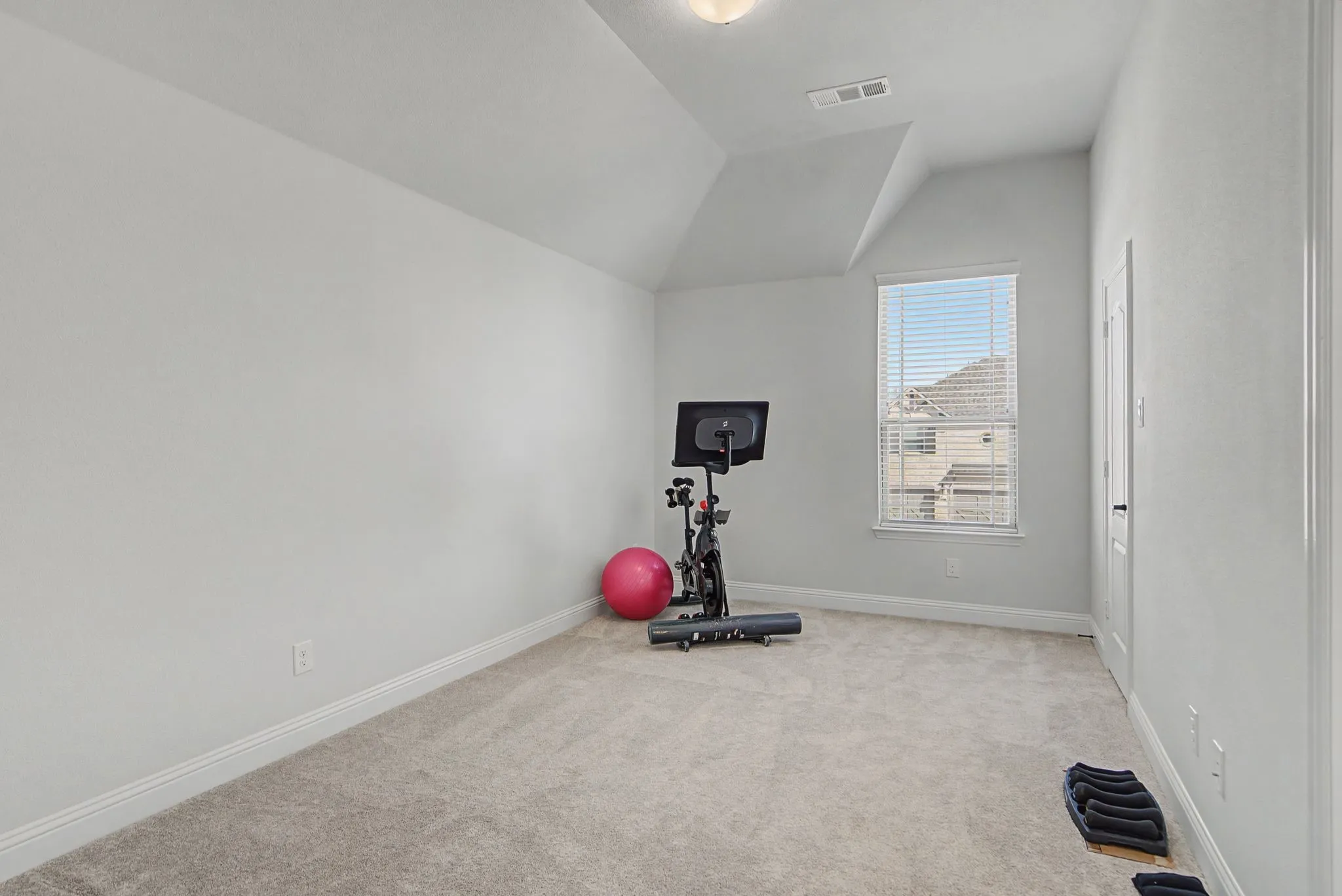Carpeted bedroom with baseboards and vaulted ceiling