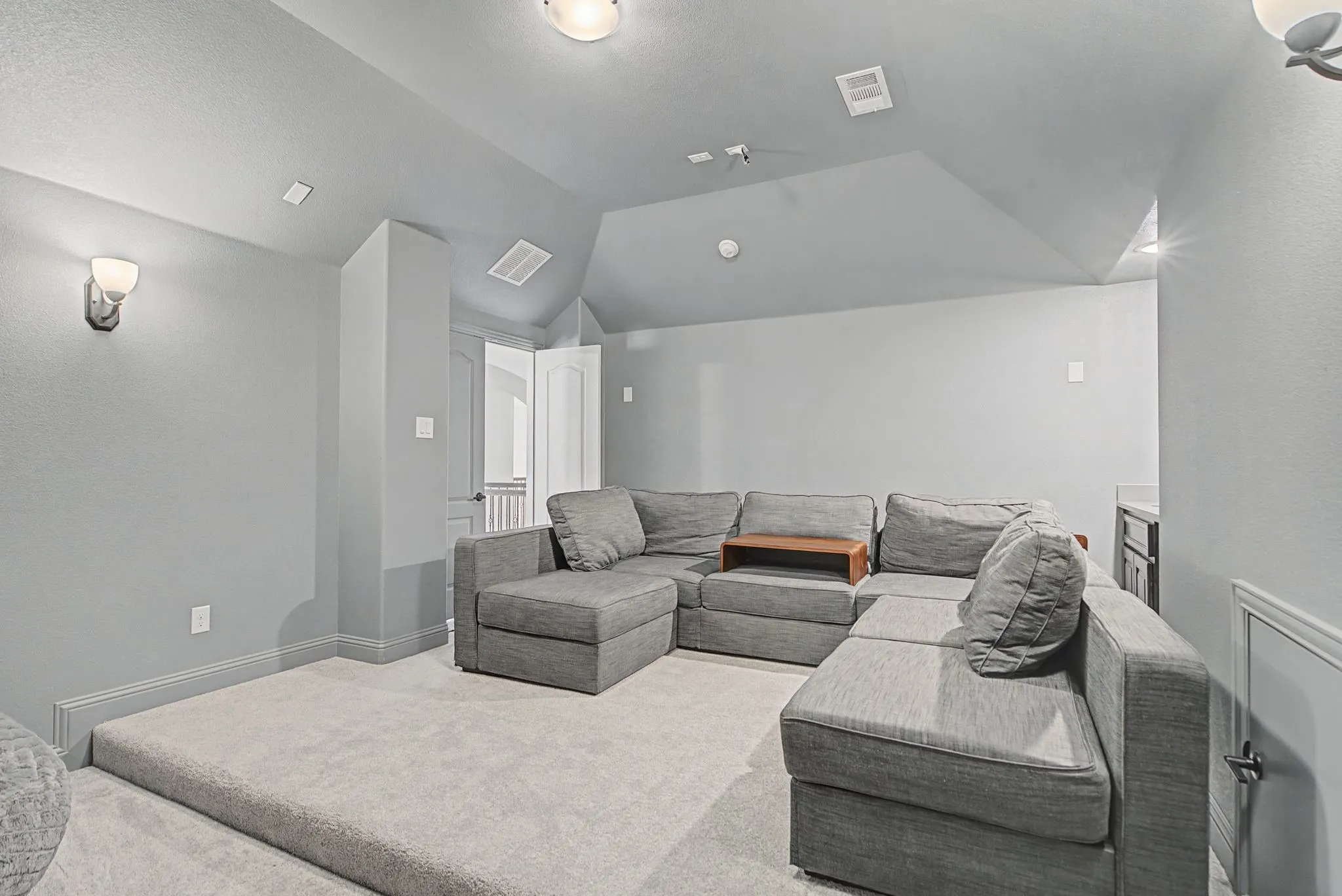 Home theater featuring carpet and vaulted ceiling