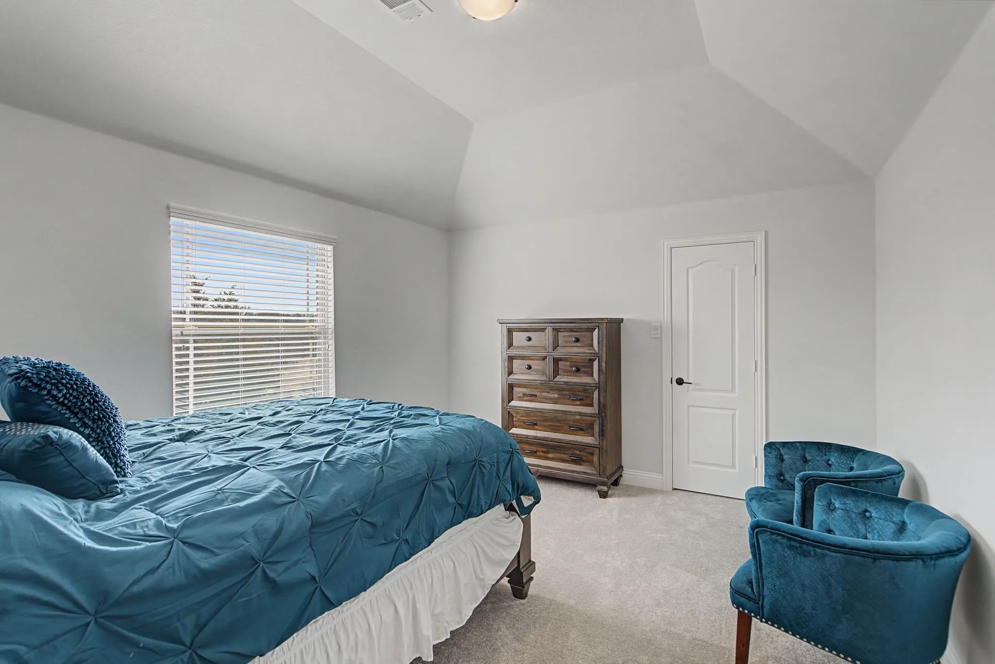 Carpeted bedroom featuring vaulted ceiling and baseboards