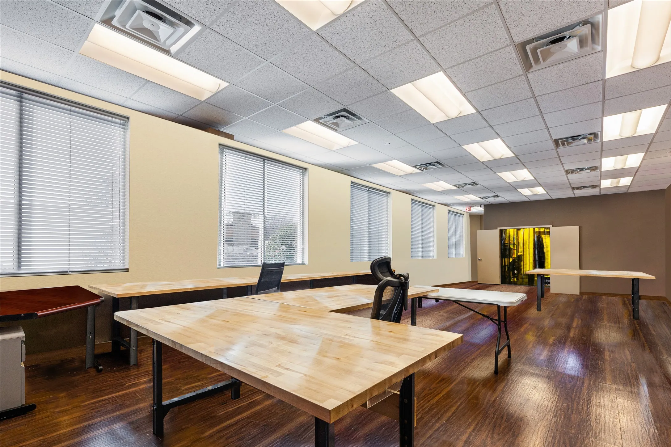 Office area with a paneled ceiling and dark wood-type flooring