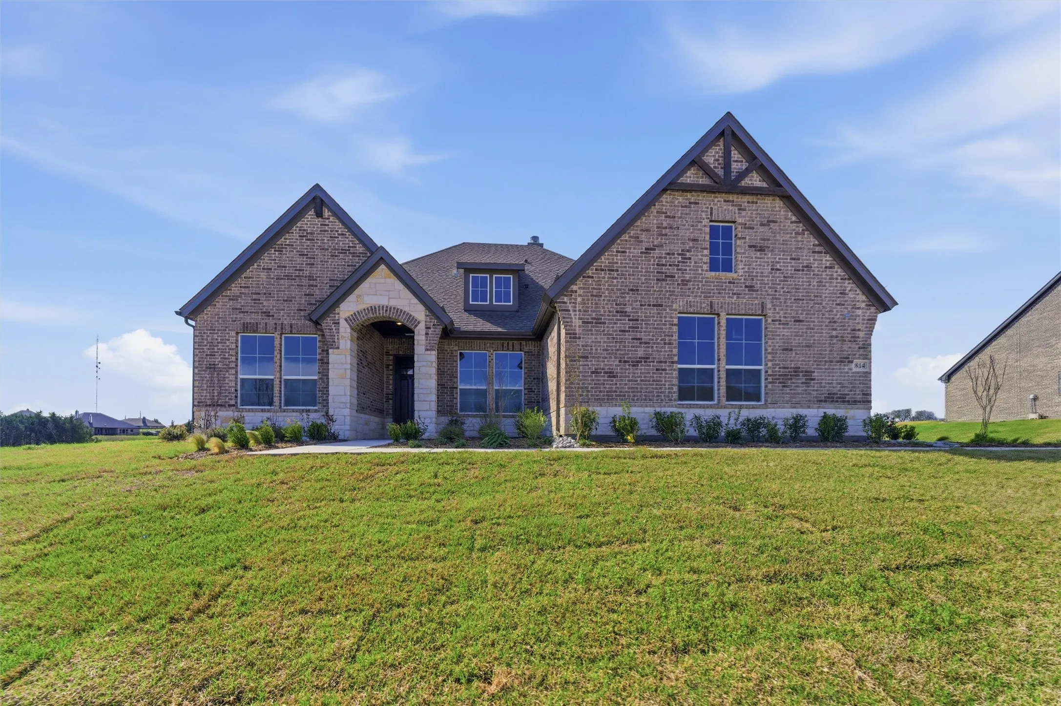 View of front facade featuring brick siding and a front lawn