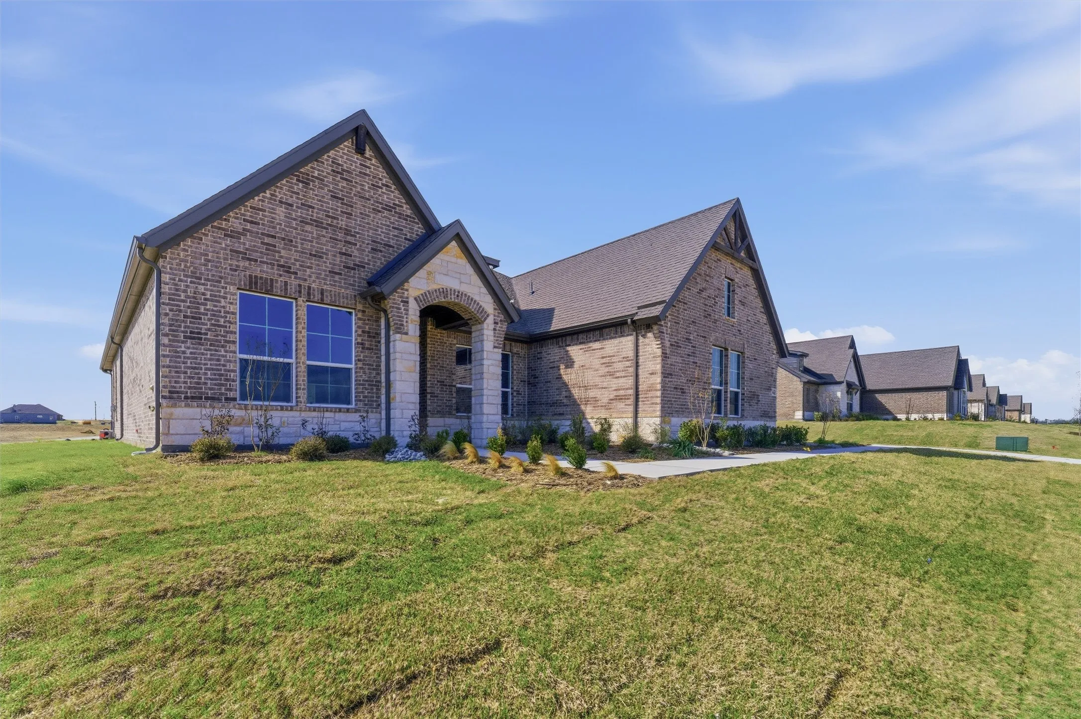 View of front facade featuring brick siding and a front yard