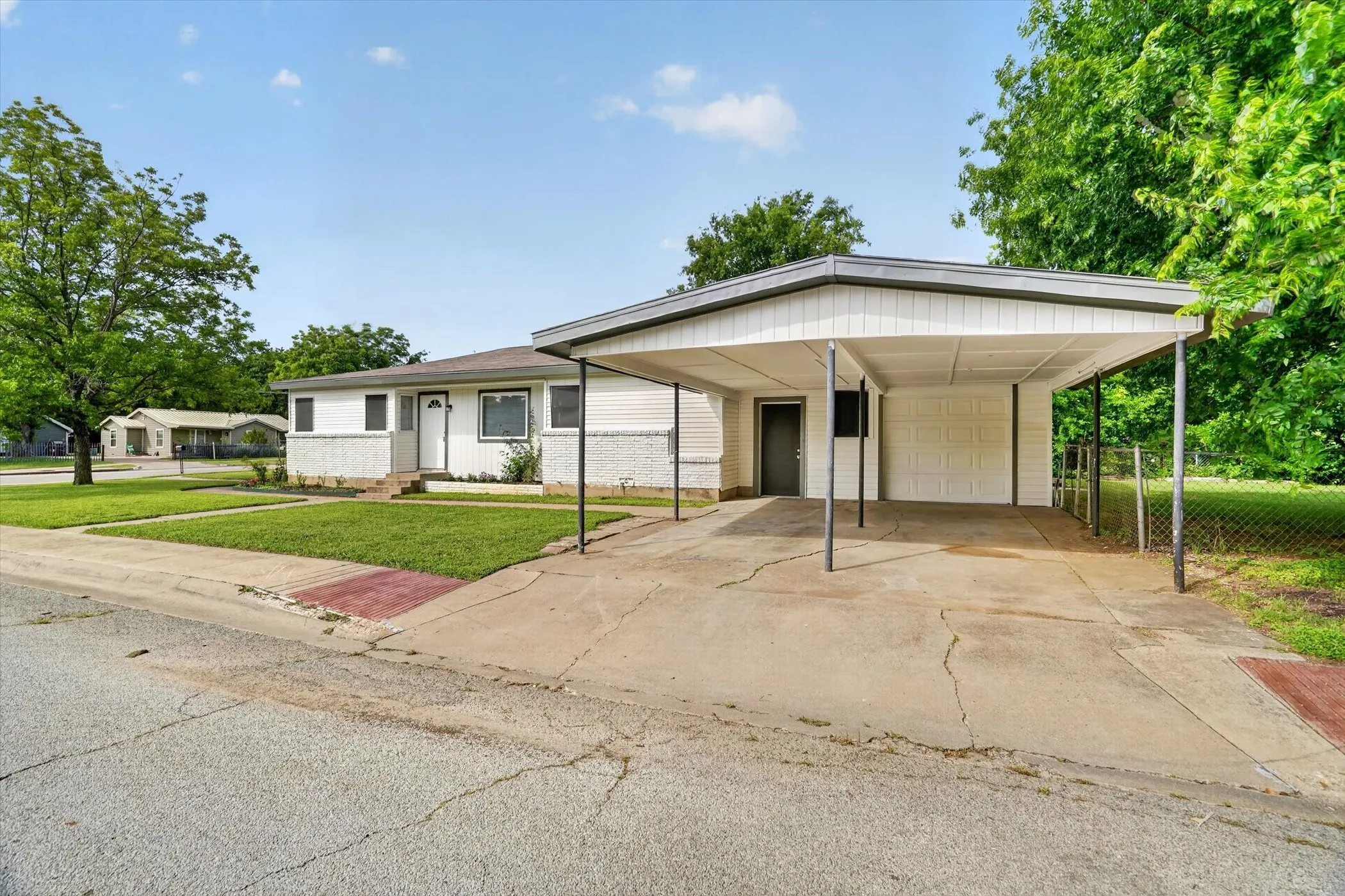 White single-story residence featuring a carport and an attached garage