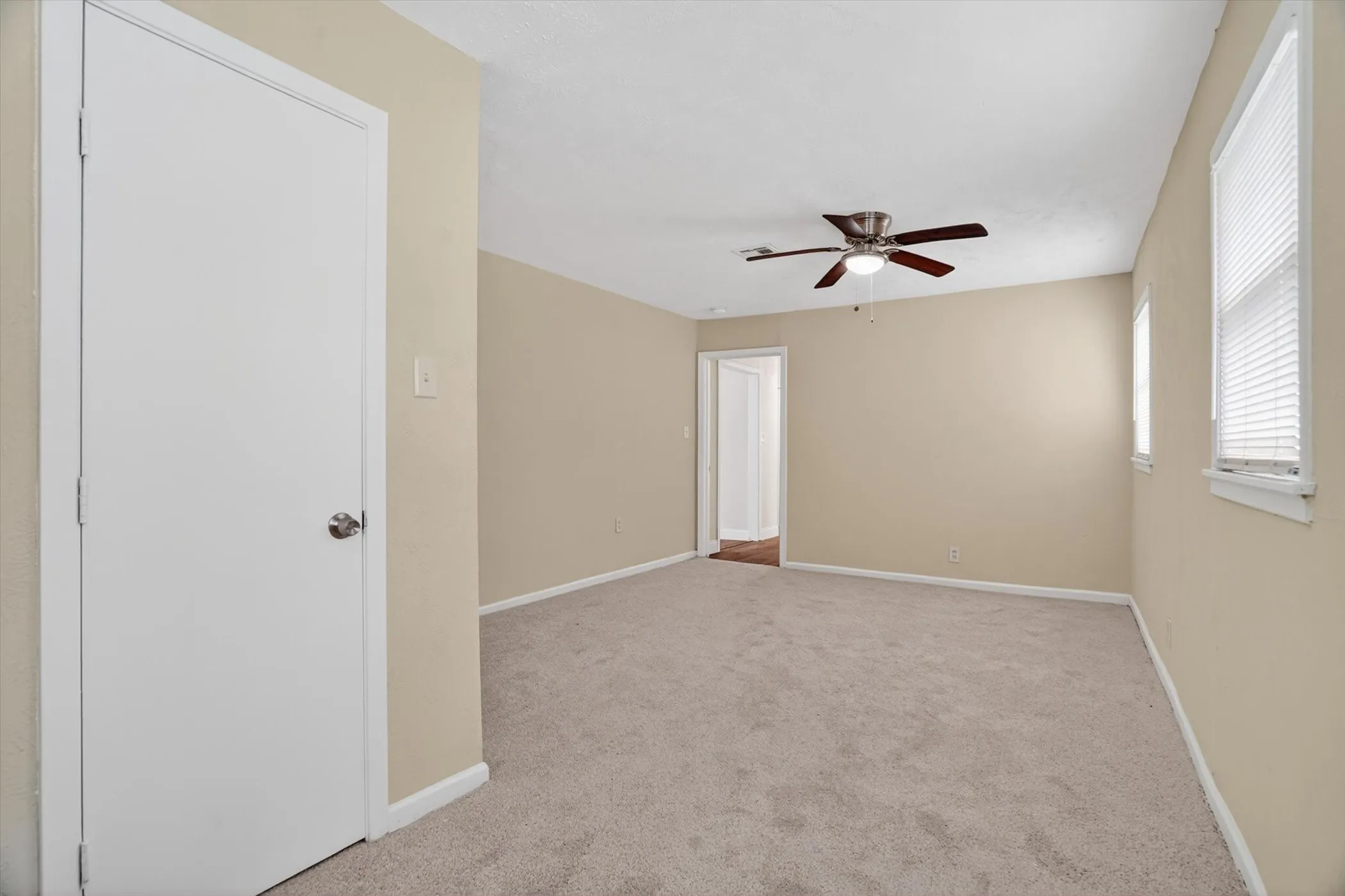Spacious room featuring neutral carpeting and light-toned walls