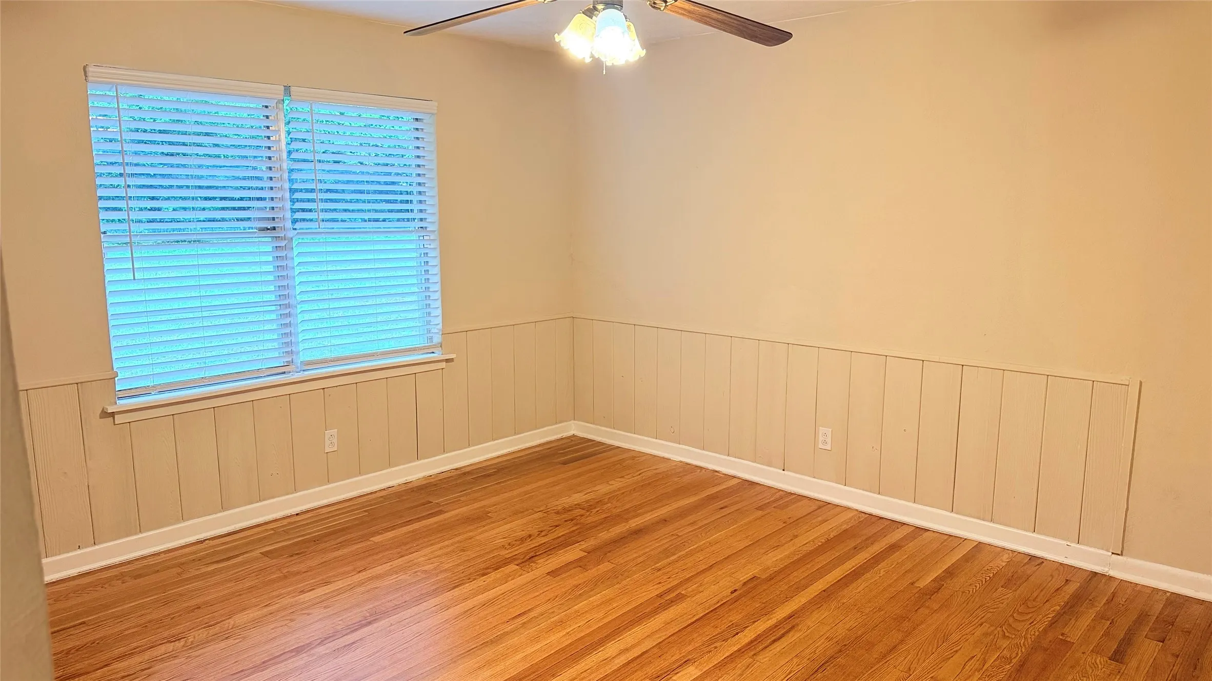 Warm wood-finish flooring complements the wainscoting and neutral wall tones