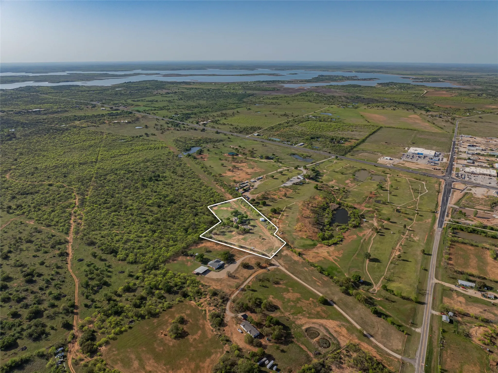 Aerial view of sparsely populated area with property parcel outlined