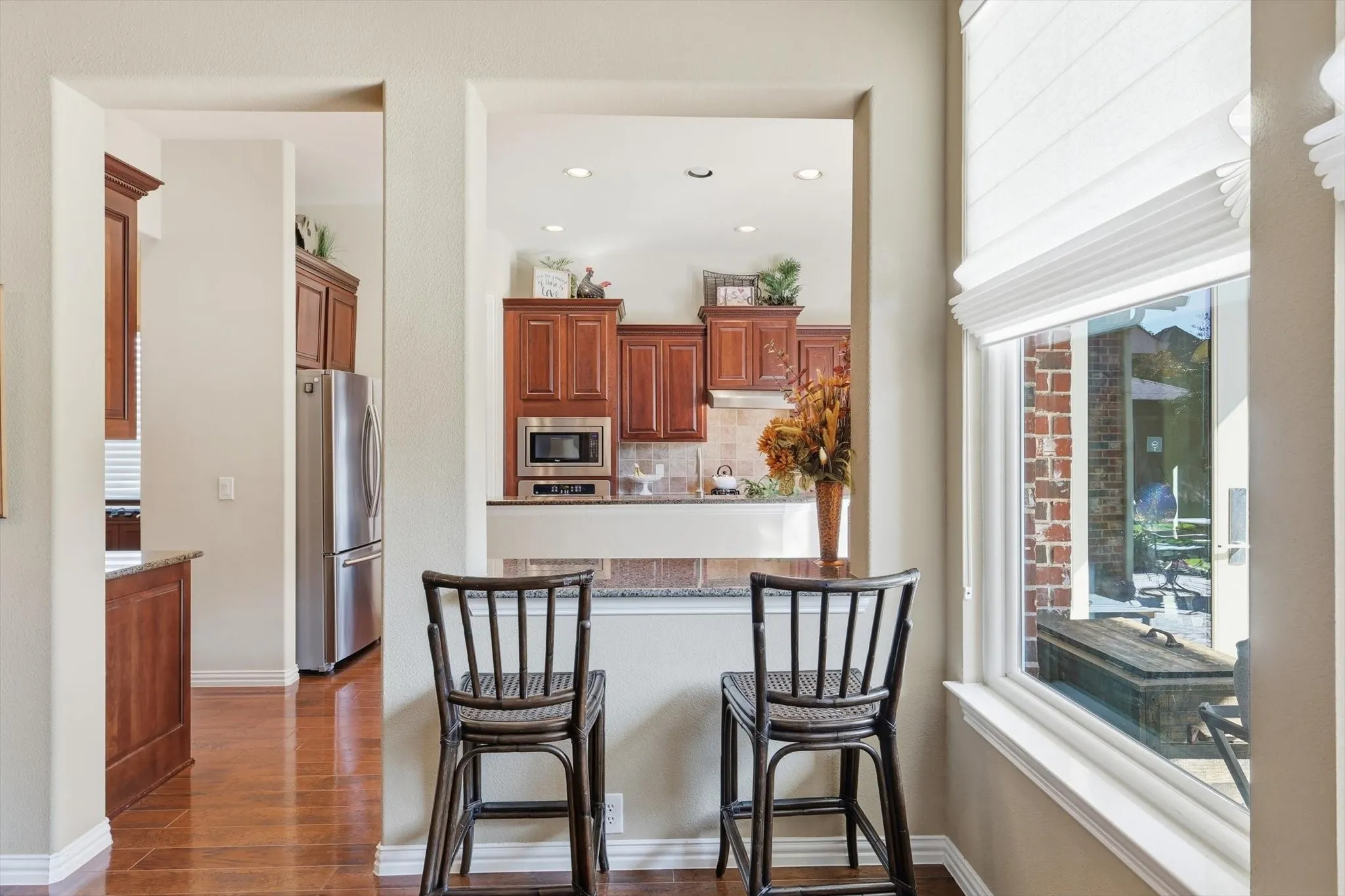 Kitchen featuring breakfast bar with a magnificent view of landscaped backyard