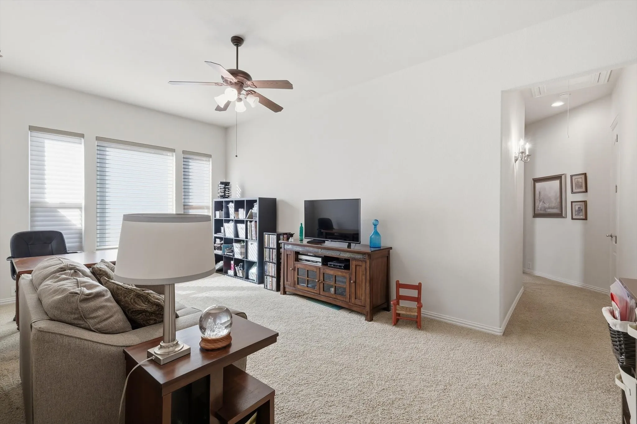 Living area featuring light colored carpet, and ceiling fan