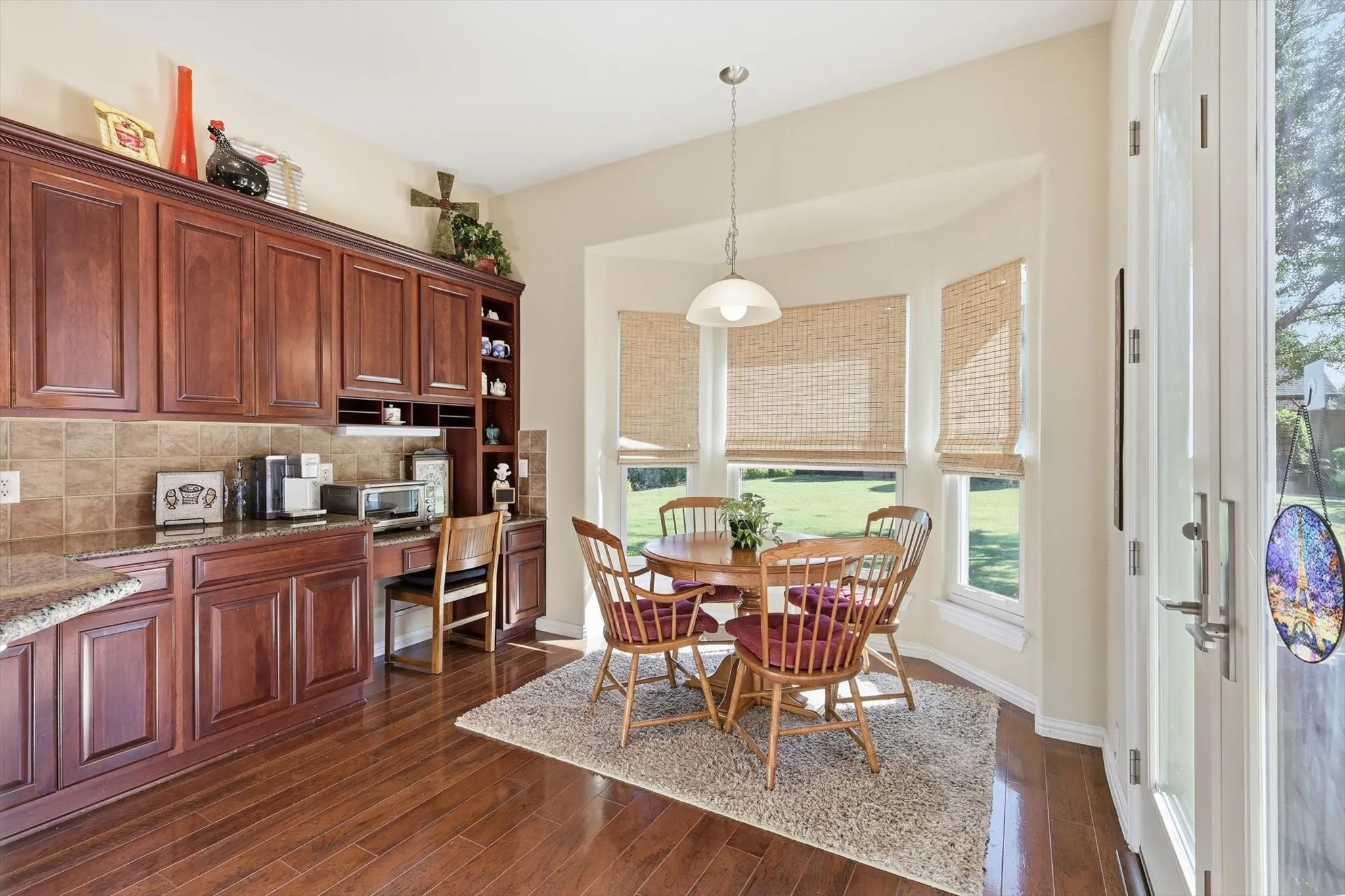 Breakfast Room with wood-type flooring and built in desk overlooks beautiful backyard