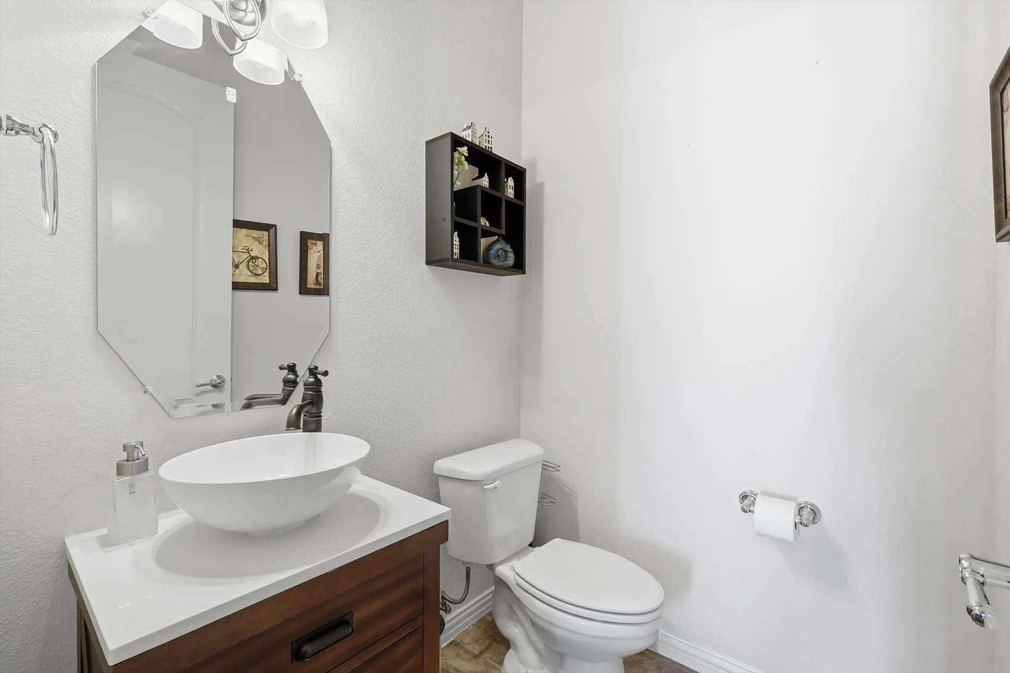 Half bathroom with vanity and a textured wall