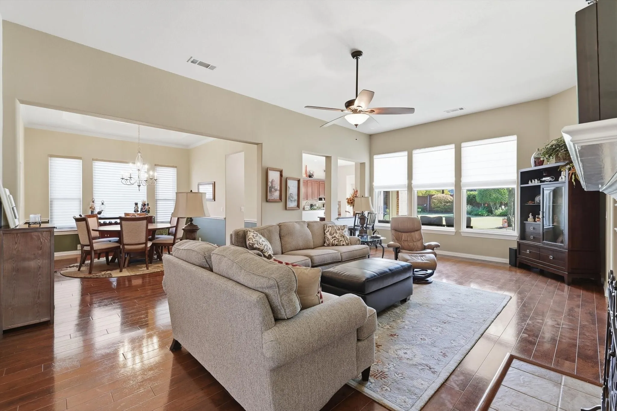 Living room with hardwood / wood-style floors, healthy amount of natural light, a ceiling fan, and a chandelier