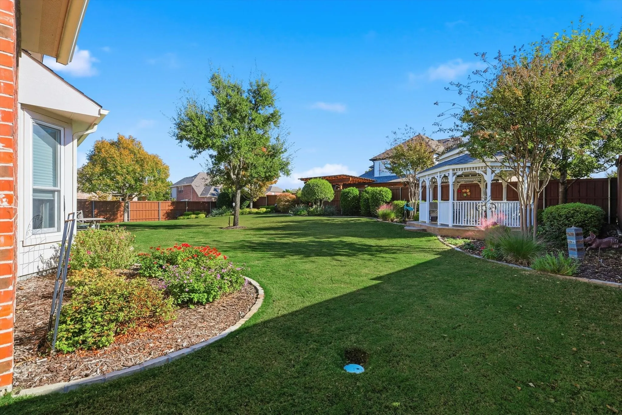 Fenced backyard with a gazebo and a patio