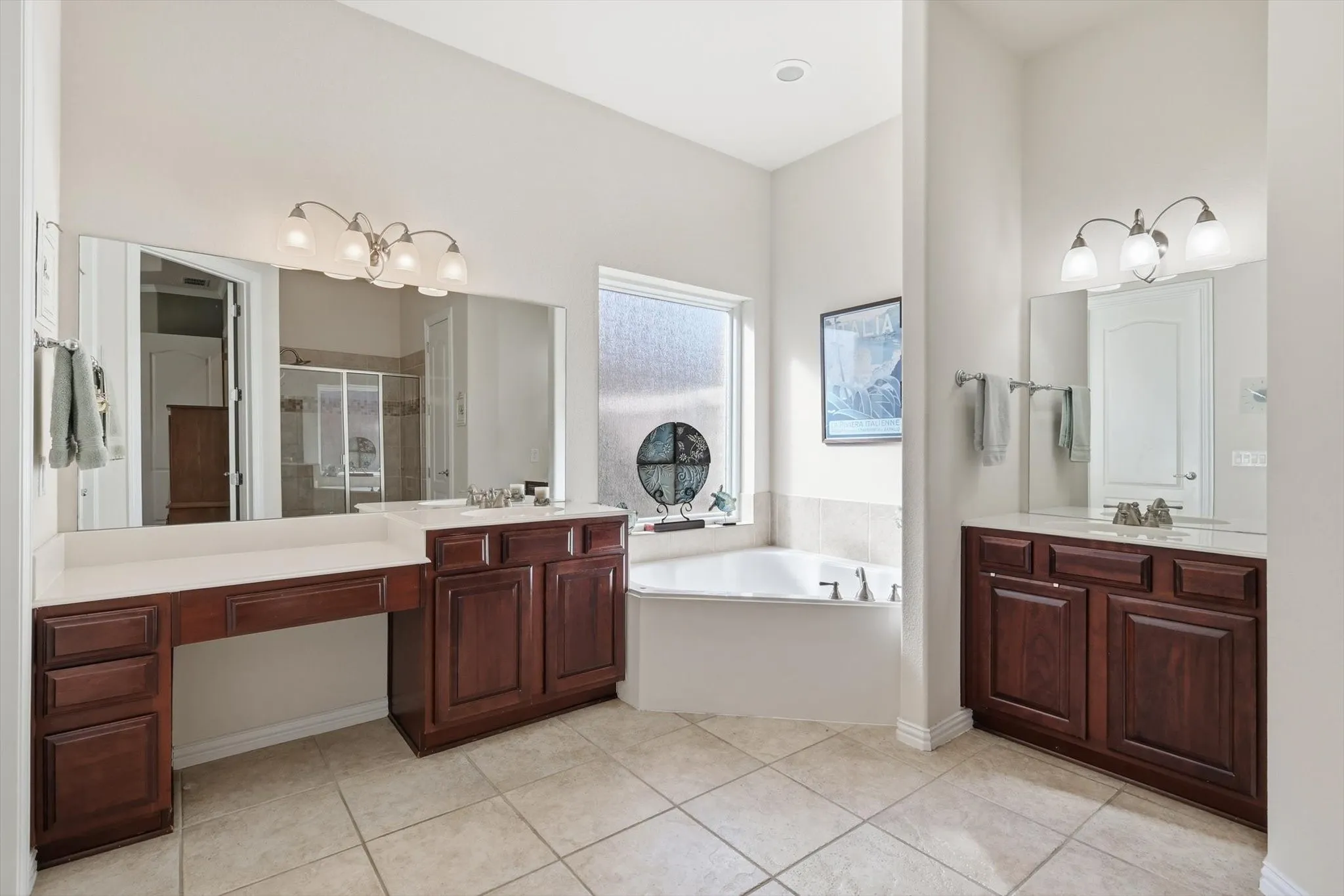 Primary Full bathroom with a walk in shower, two vanities, a jetted garden tub, and light tile patterned floors