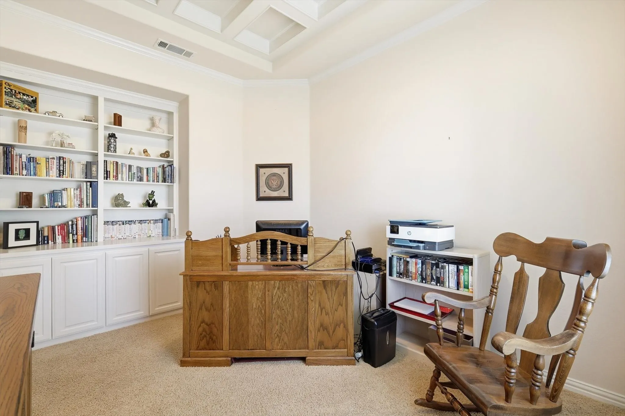 Office area featuring built in shelves and cabinet, light colored carpet, crown molding, and coffered ceiling