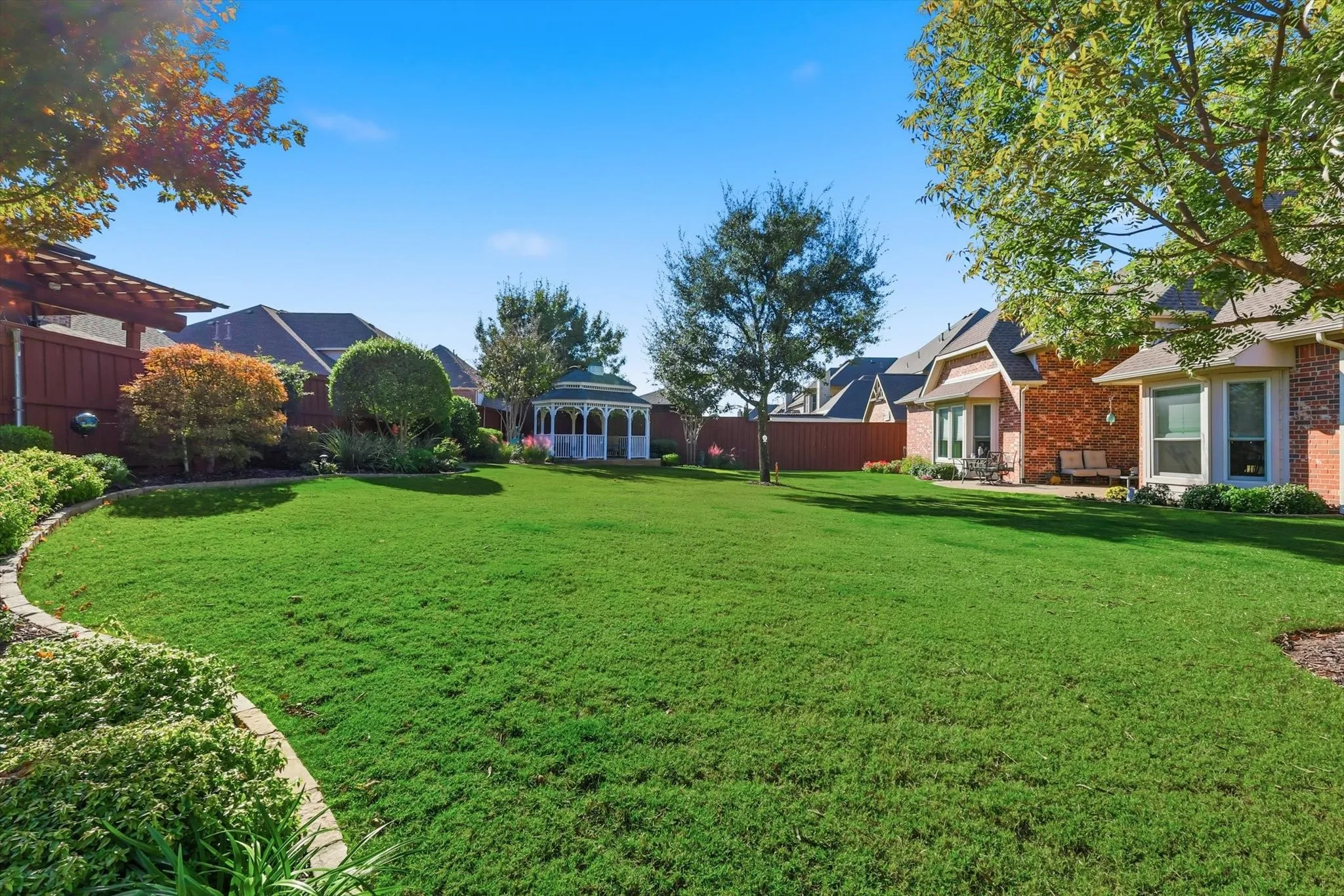 Large Landscaped Backyard with Gazebo and Wood Fence