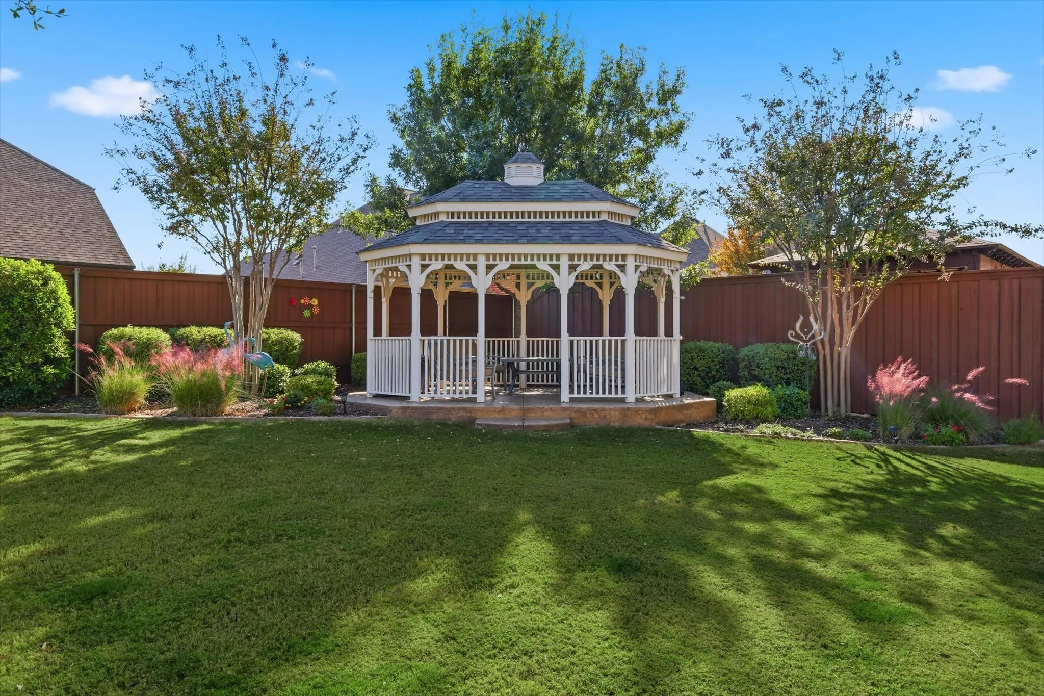 Fenced backyard featuring a gazebo and a patio area