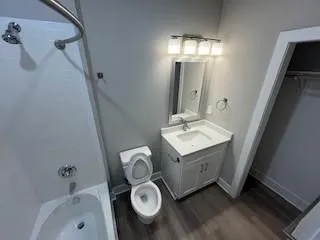Tub & Shower combination with high mounted shower head, granited counter tops, bright lighting.