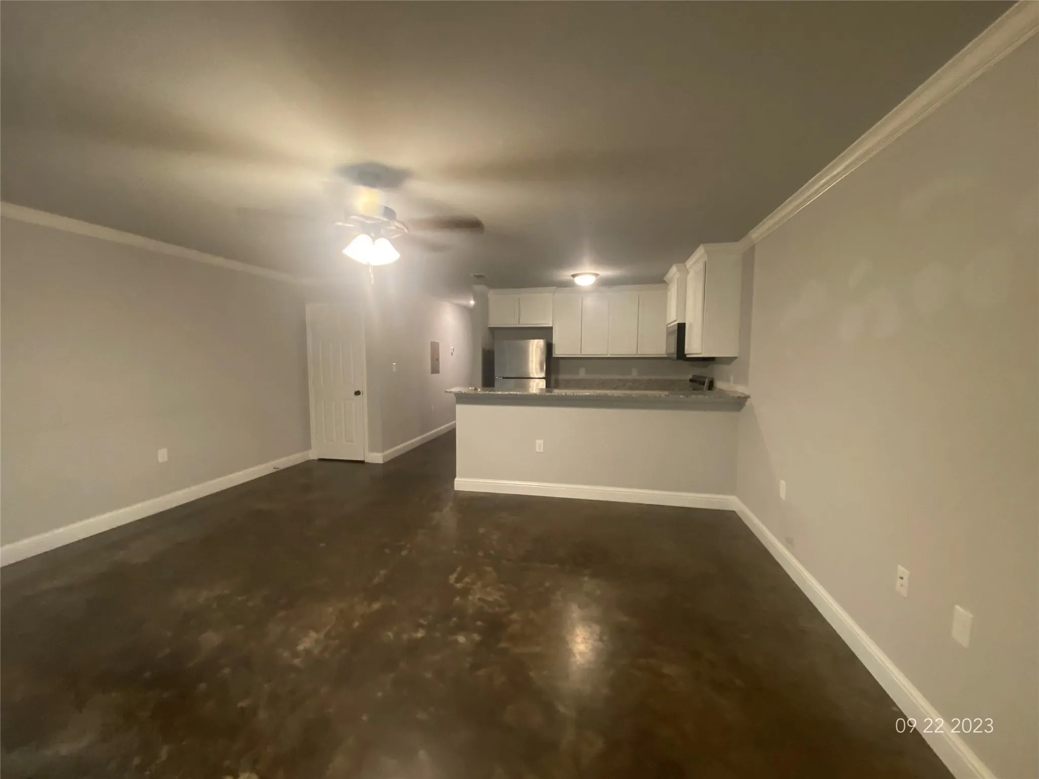 Large Open floor plan with neutral colors, ceiling fan and concrete flooring