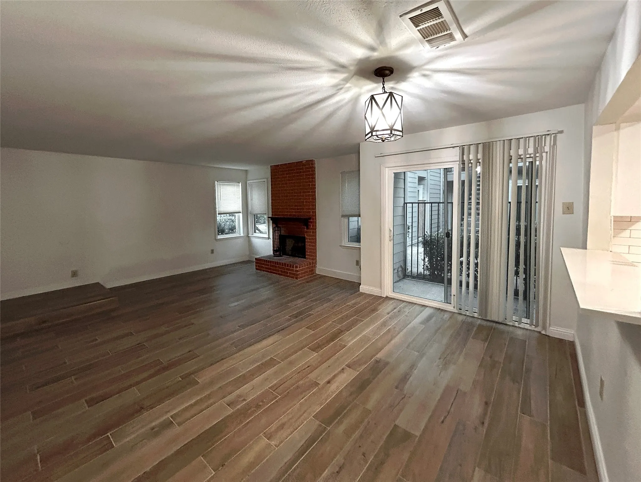 The sunken living room features ceramic tile flooring. The dining area has a chandelier, a sliding glass door to the patio and a breakfast bar to the kitchen.