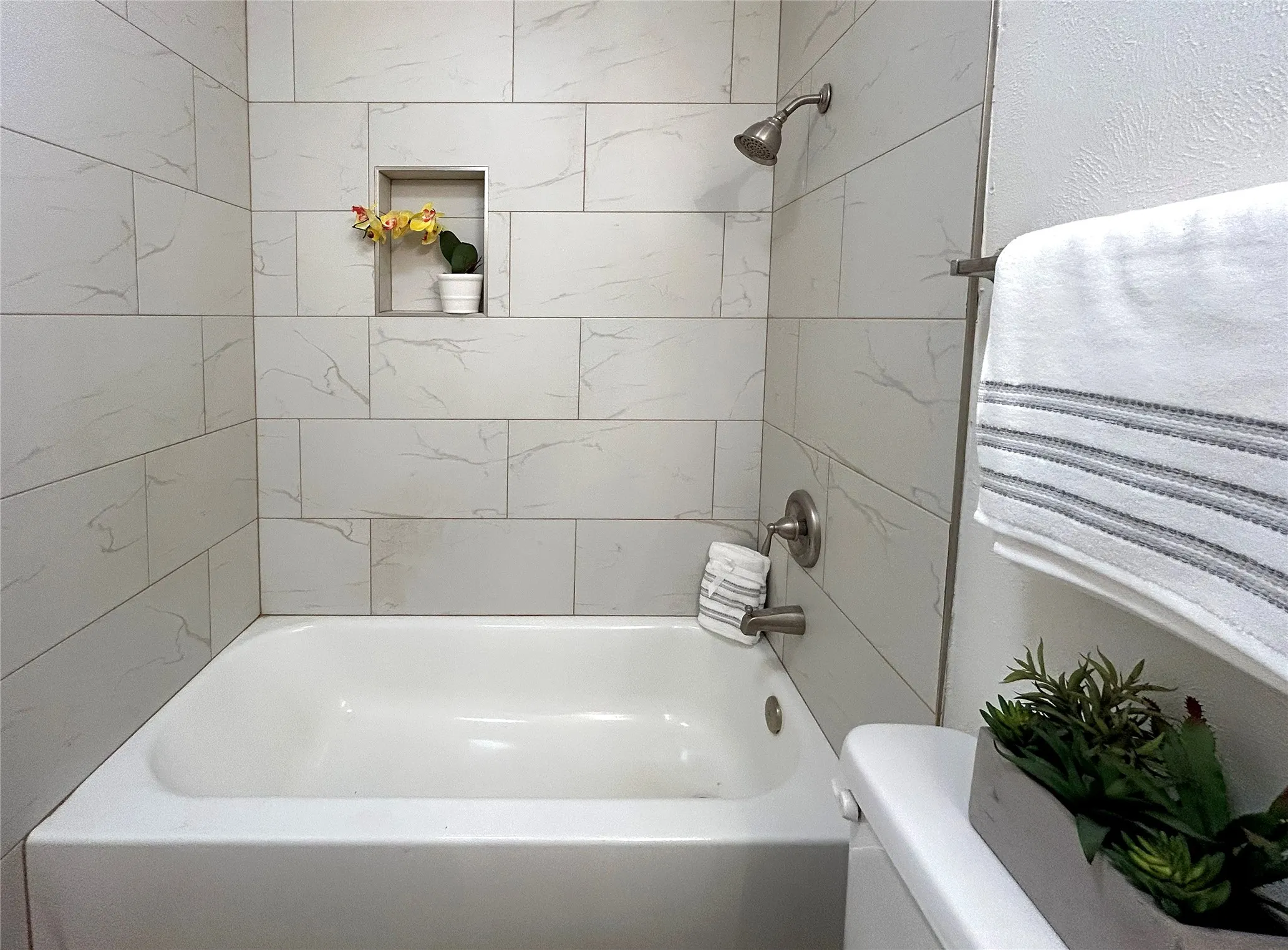 The secondary bath has a shower/bath combo, a white vanity and a cute towel closet with louvered doors.