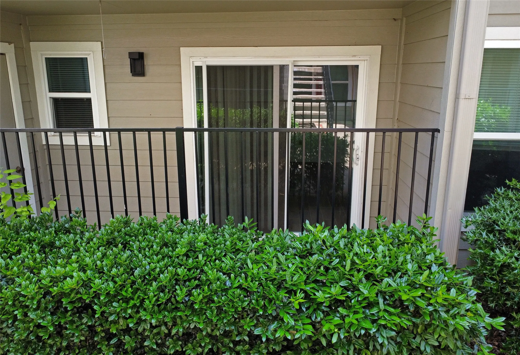View of covered and fenced patio with a sliding door and extra storage