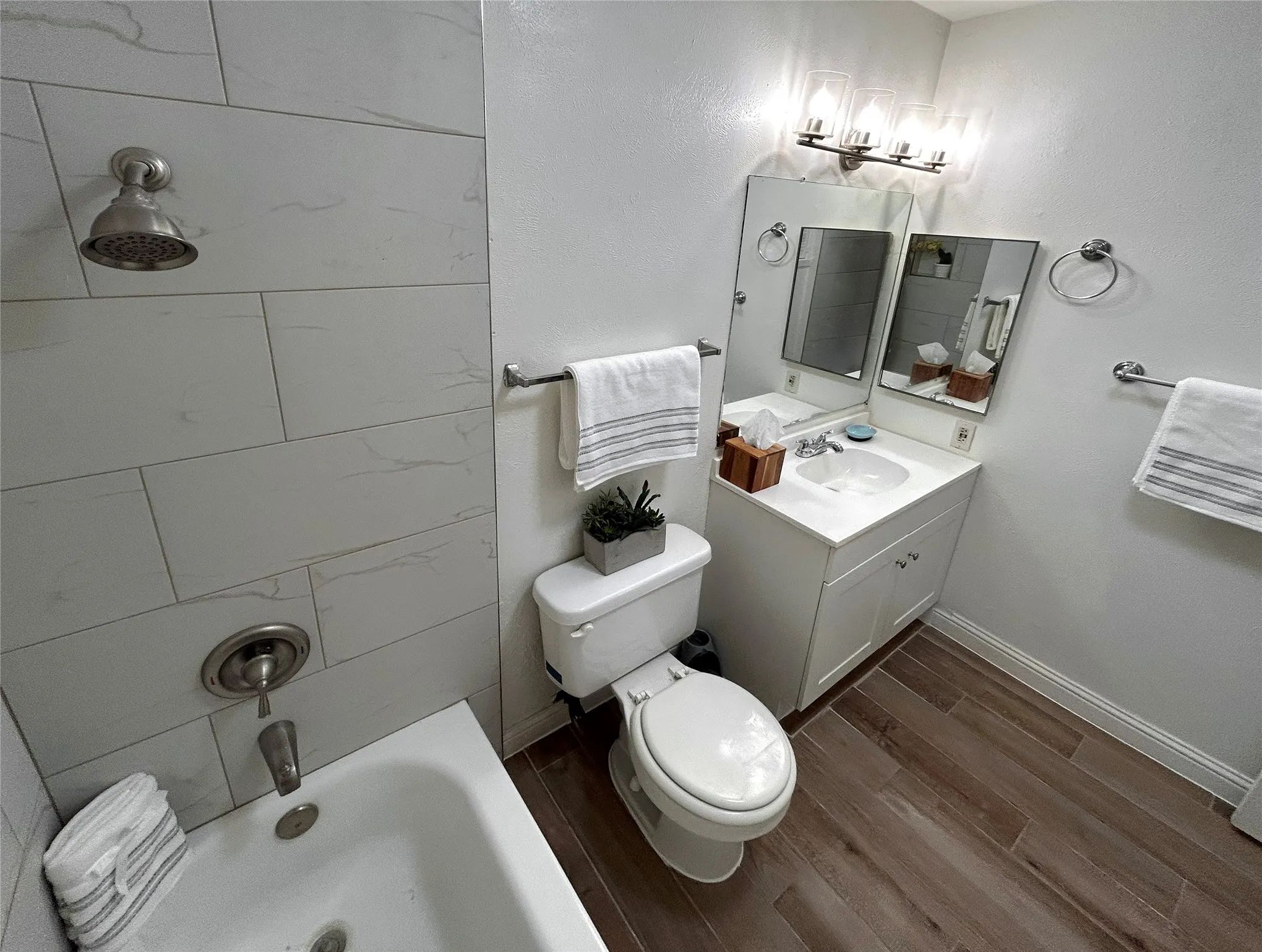 The secondary bath has a shower/bath combo, a white vanity and a medicine cabinet.