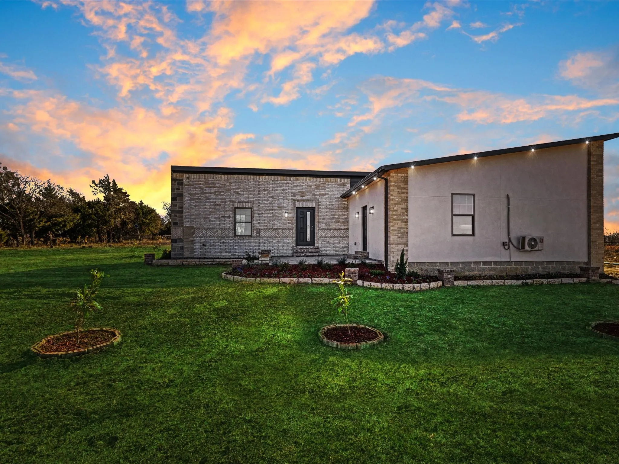 View of front facade with a lawn and stucco siding