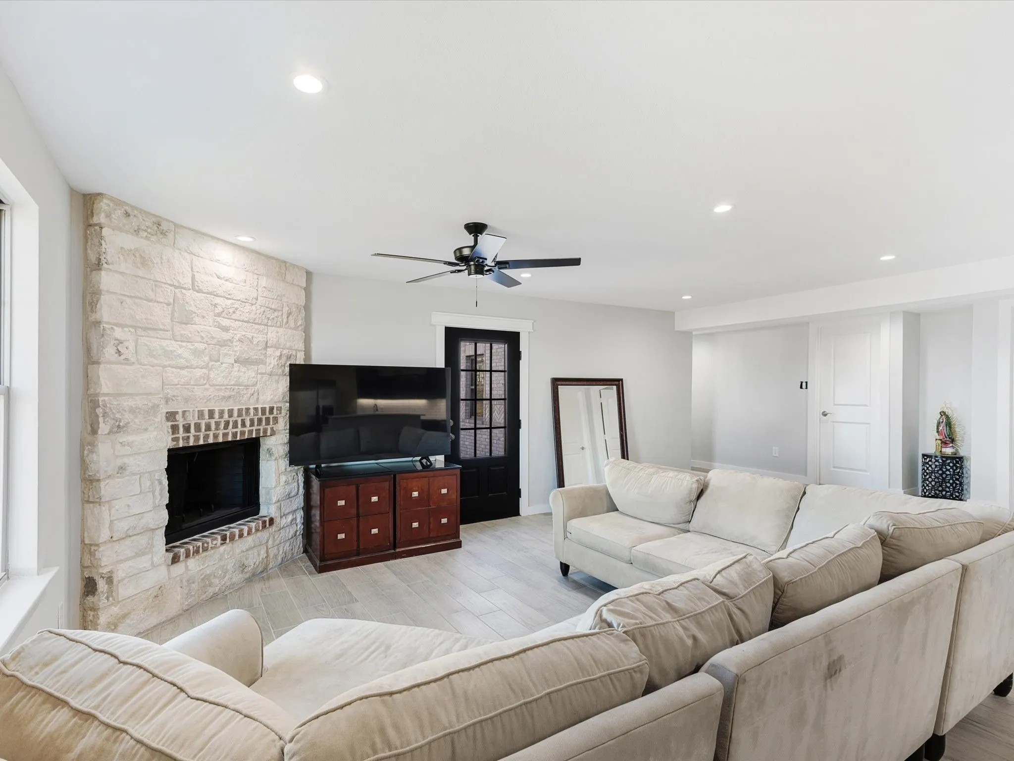Living area featuring wood finished floors, a fireplace, a ceiling fan, and recessed lighting