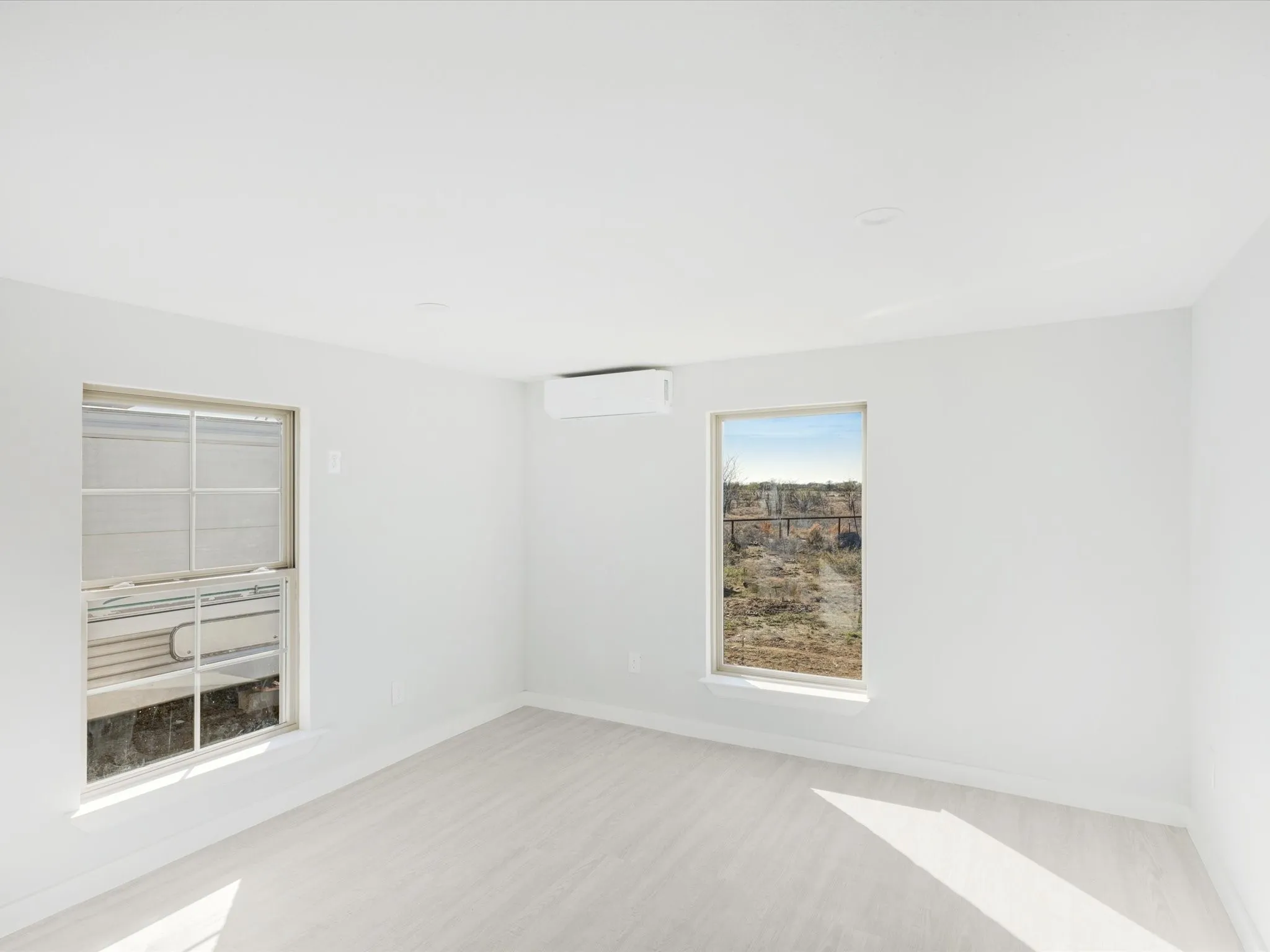 Empty room with baseboards and a wall mounted mini split