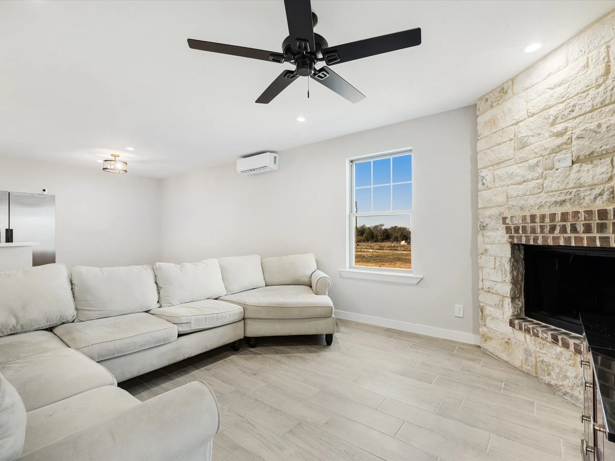 Living area featuring wood finish floors, a ceiling fan, recessed lighting, and a fireplace