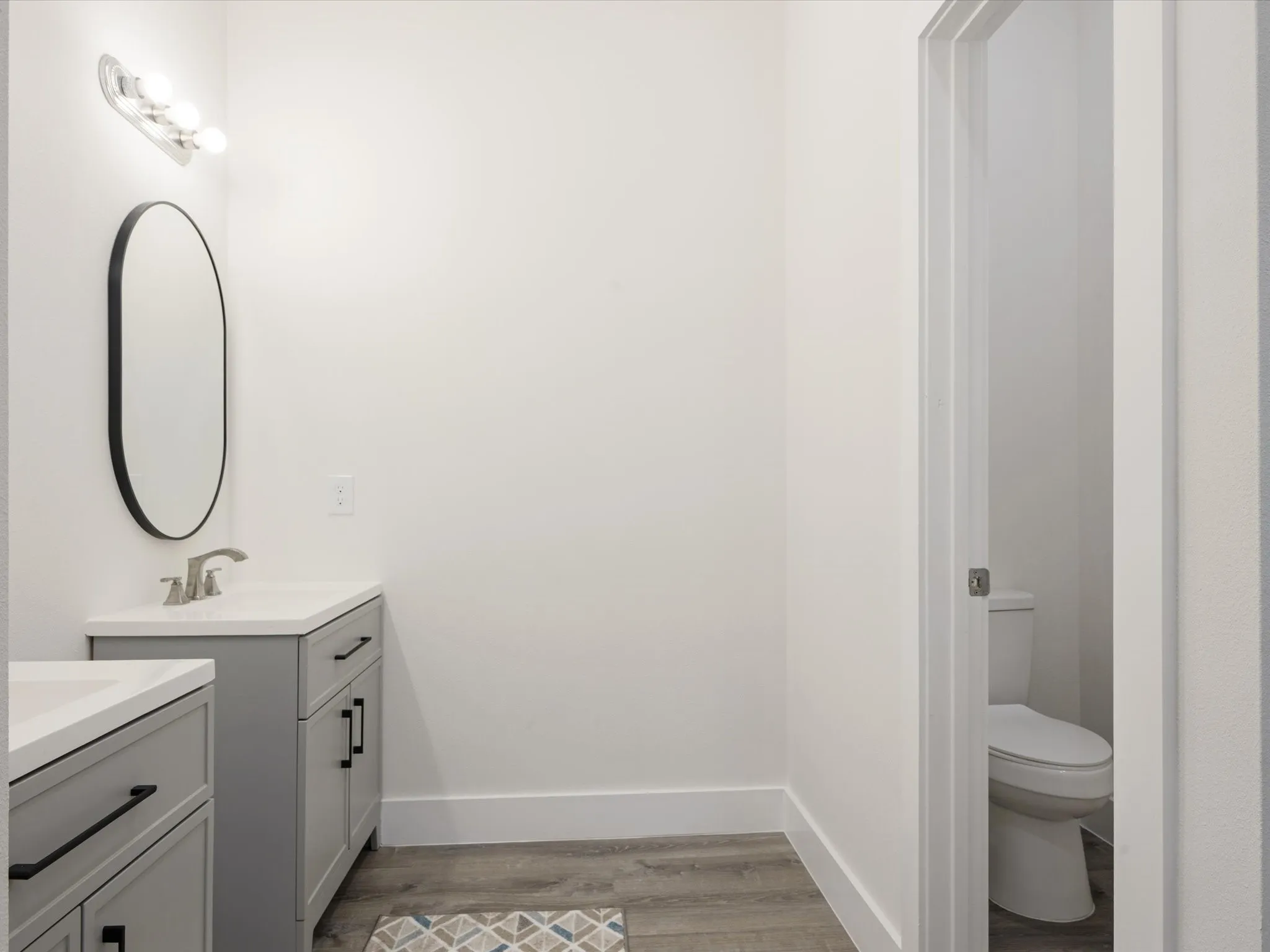 Bathroom with two vanities and light wood-type flooring