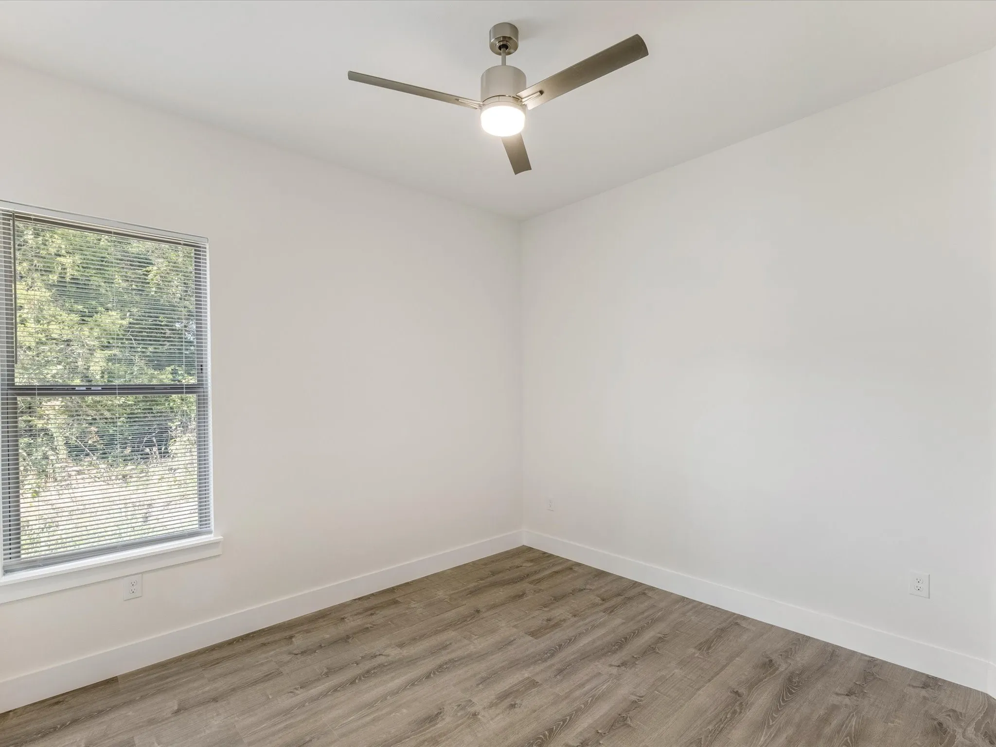 Spare room with wood finished floors and a ceiling fan