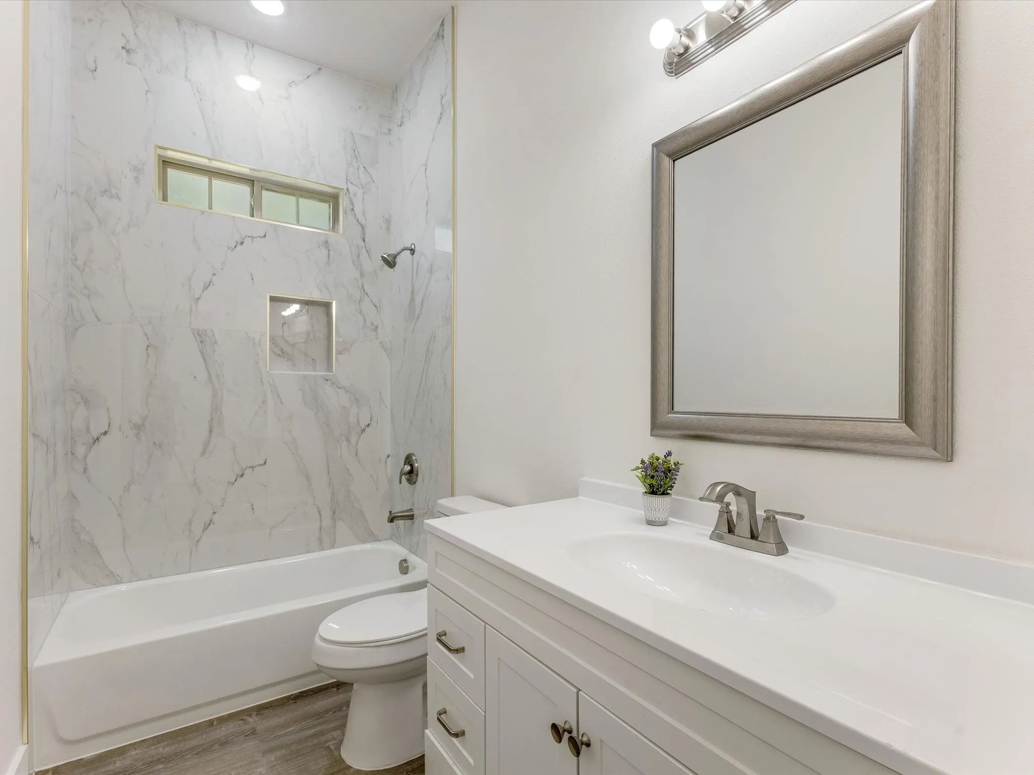 Bathroom with vanity, bathing tub / shower combination, and light wood-type flooring