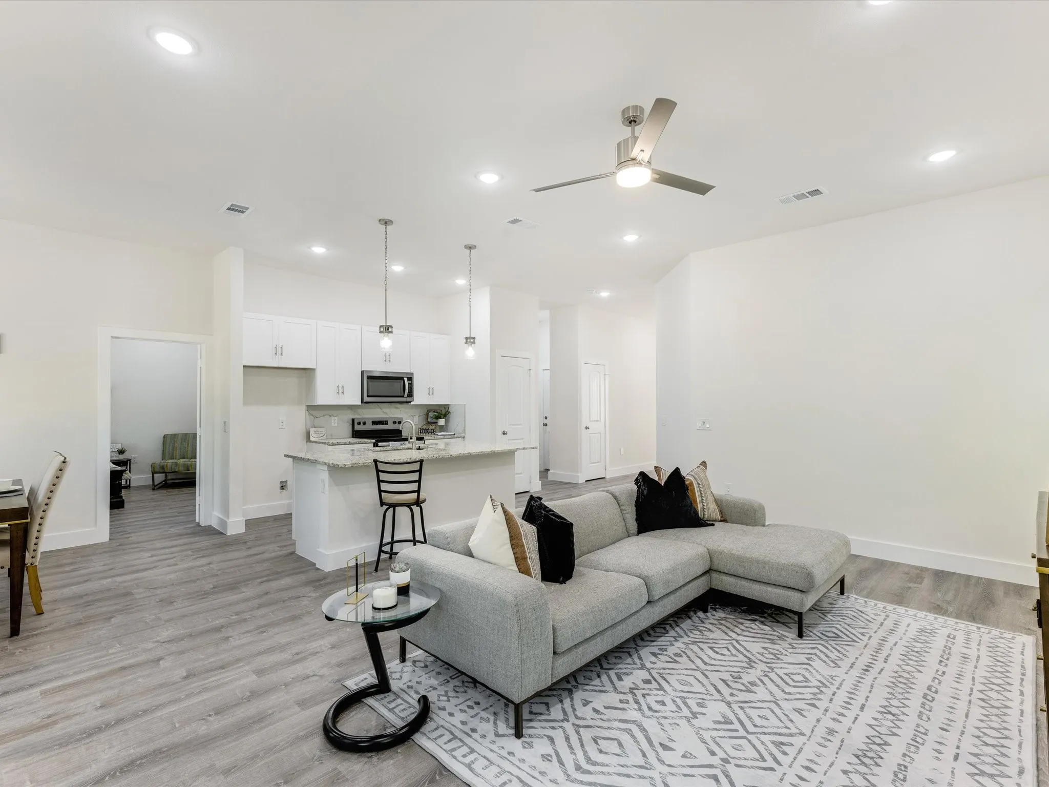 Living area with light wood-type flooring, ceiling fan, and recessed lighting