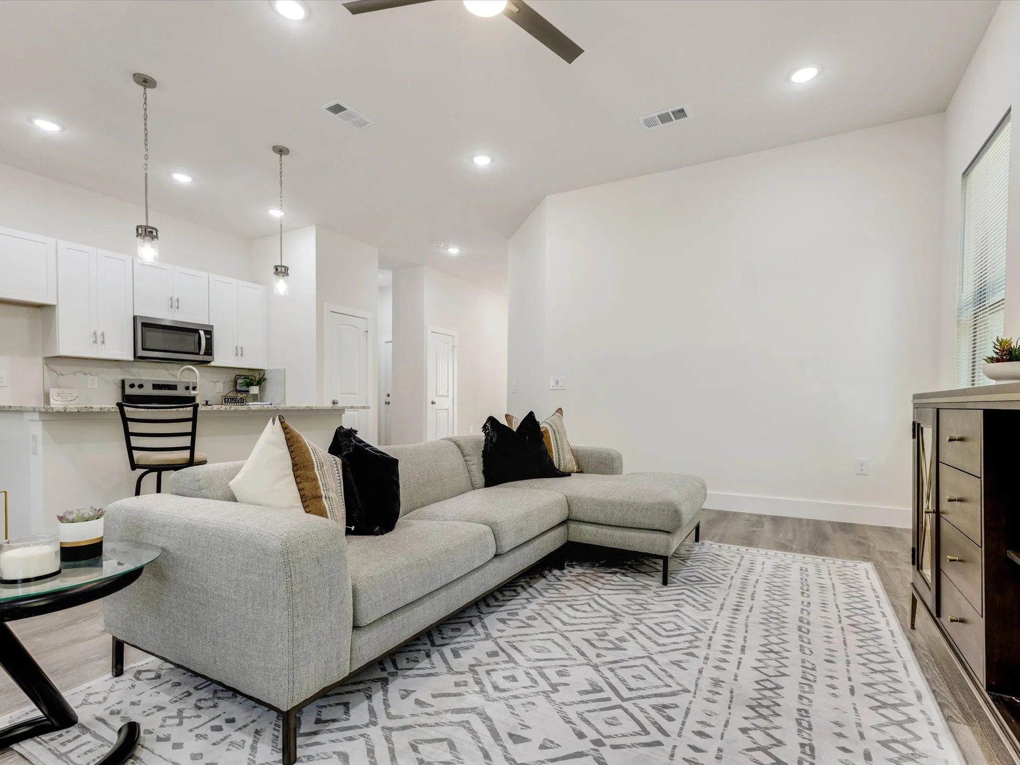 Living area with ceiling fan, light wood-style floors, and recessed lighting