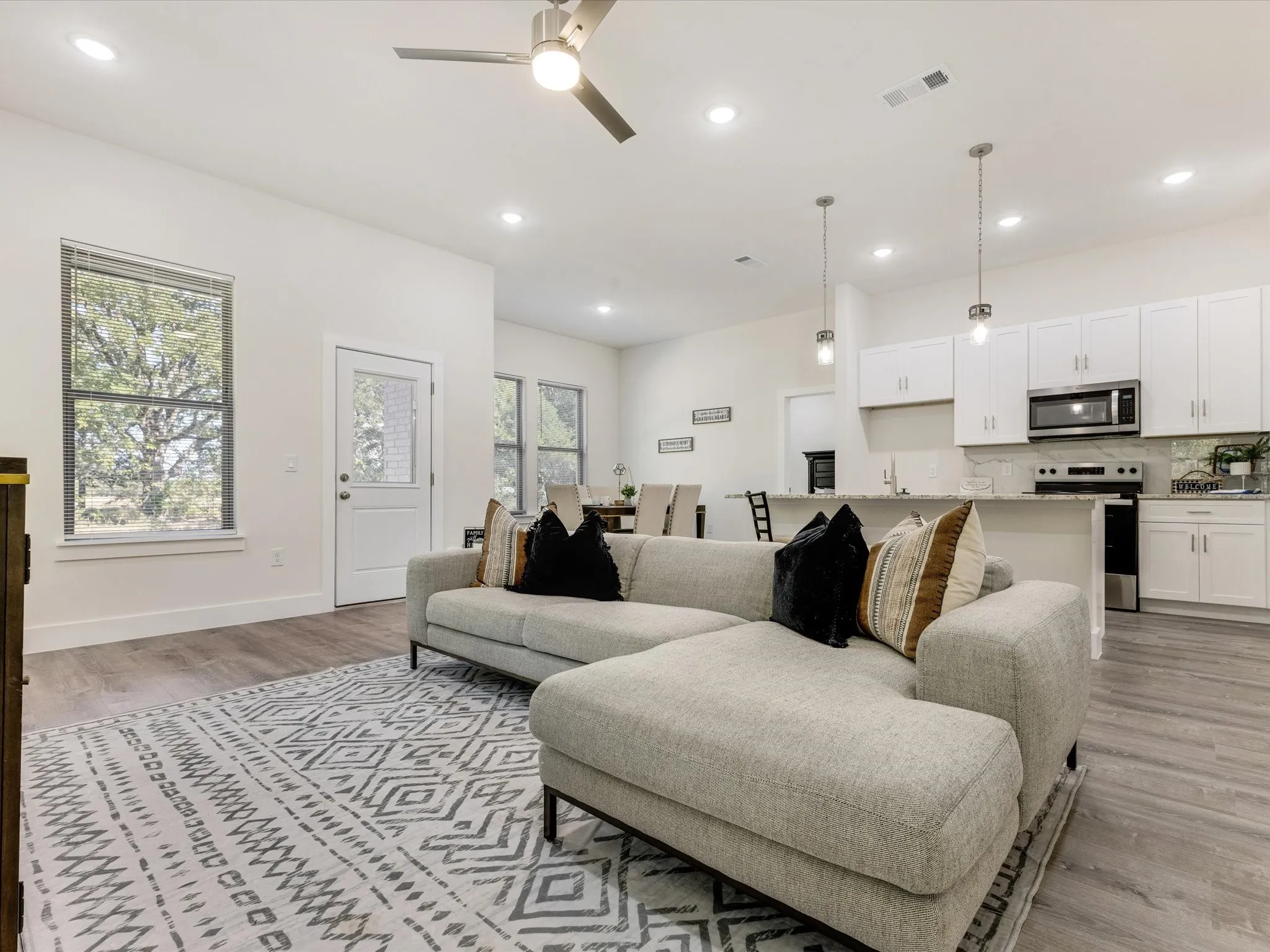 Living area featuring a ceiling fan, light wood finished floors, and recessed lighting