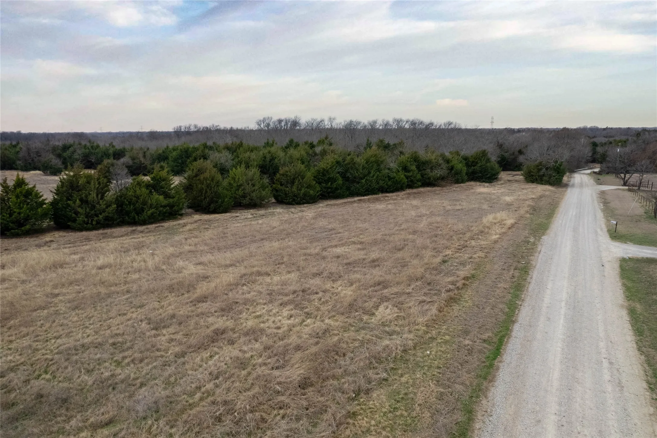 View of dirt / gravel road featuring a view of rural / pastoral area
